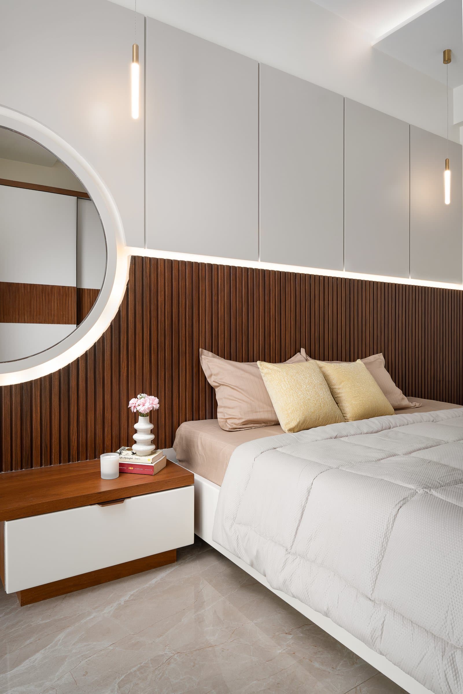 The master's second wall: fluted wood, a circular backlit mirror, and a band of indirect light