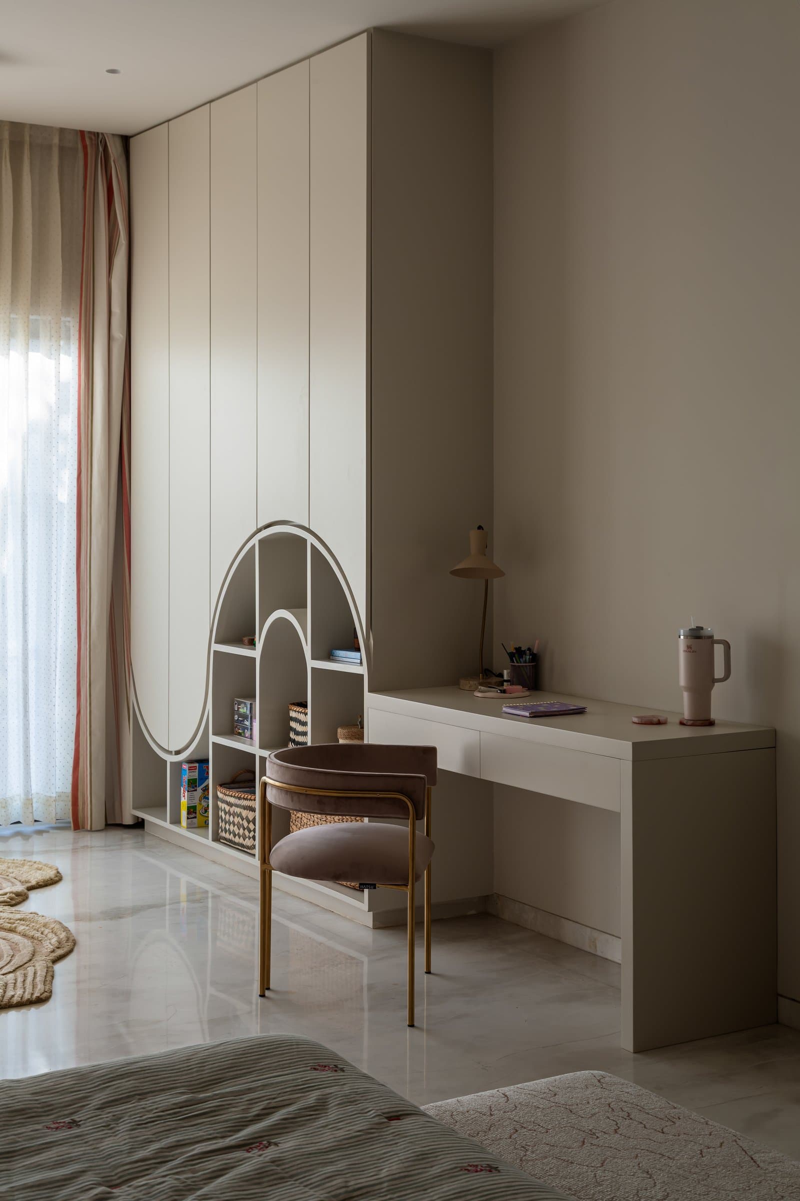 The same room's study corner, where nested arches are cut into the wardrobe wall as display niches
