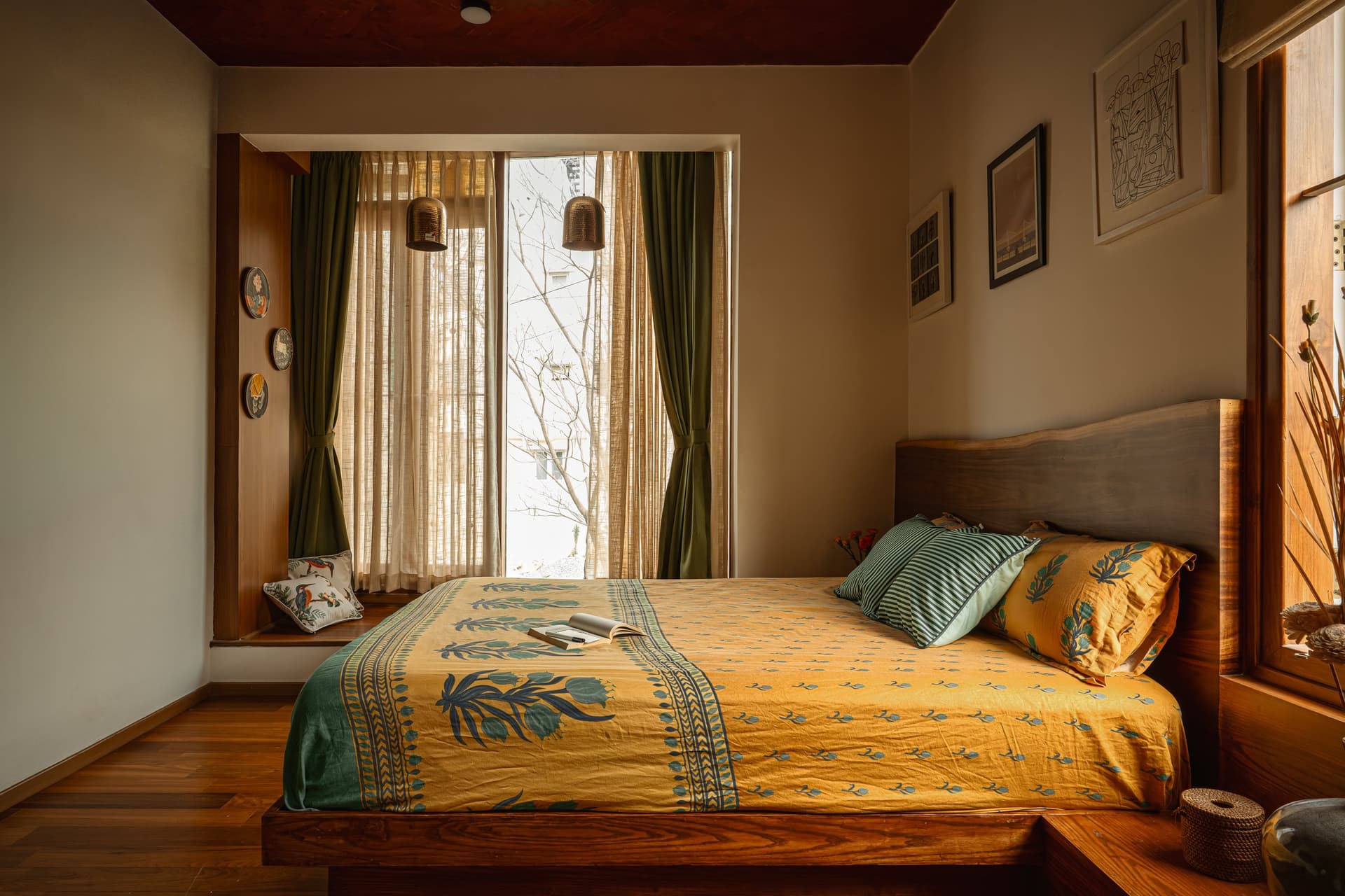 The first bedroom, organised around a deep window seat and two rattan pendants