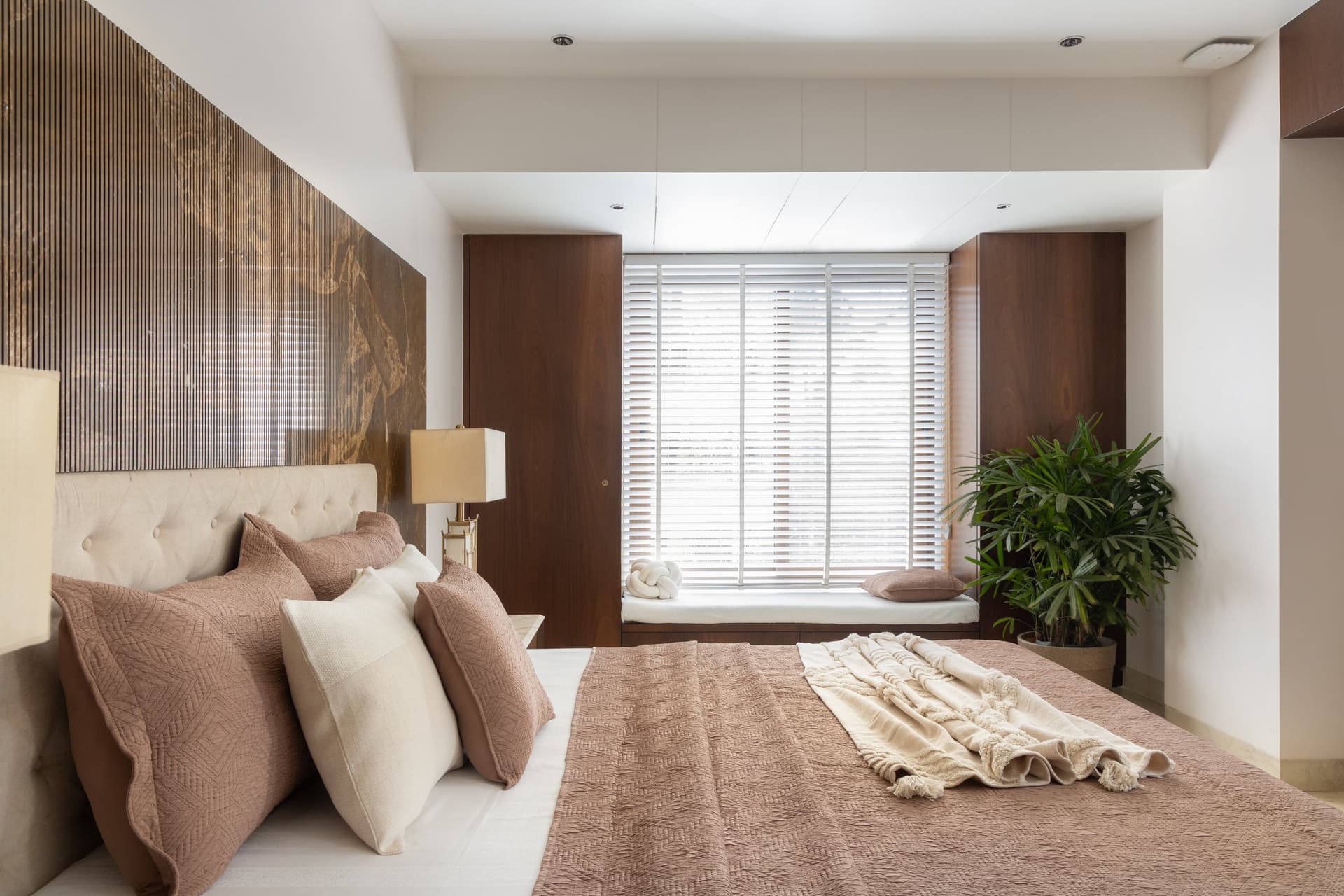 The master bedroom, the fluted-and-patinated headboard wall reading almost as a landscape behind the bed