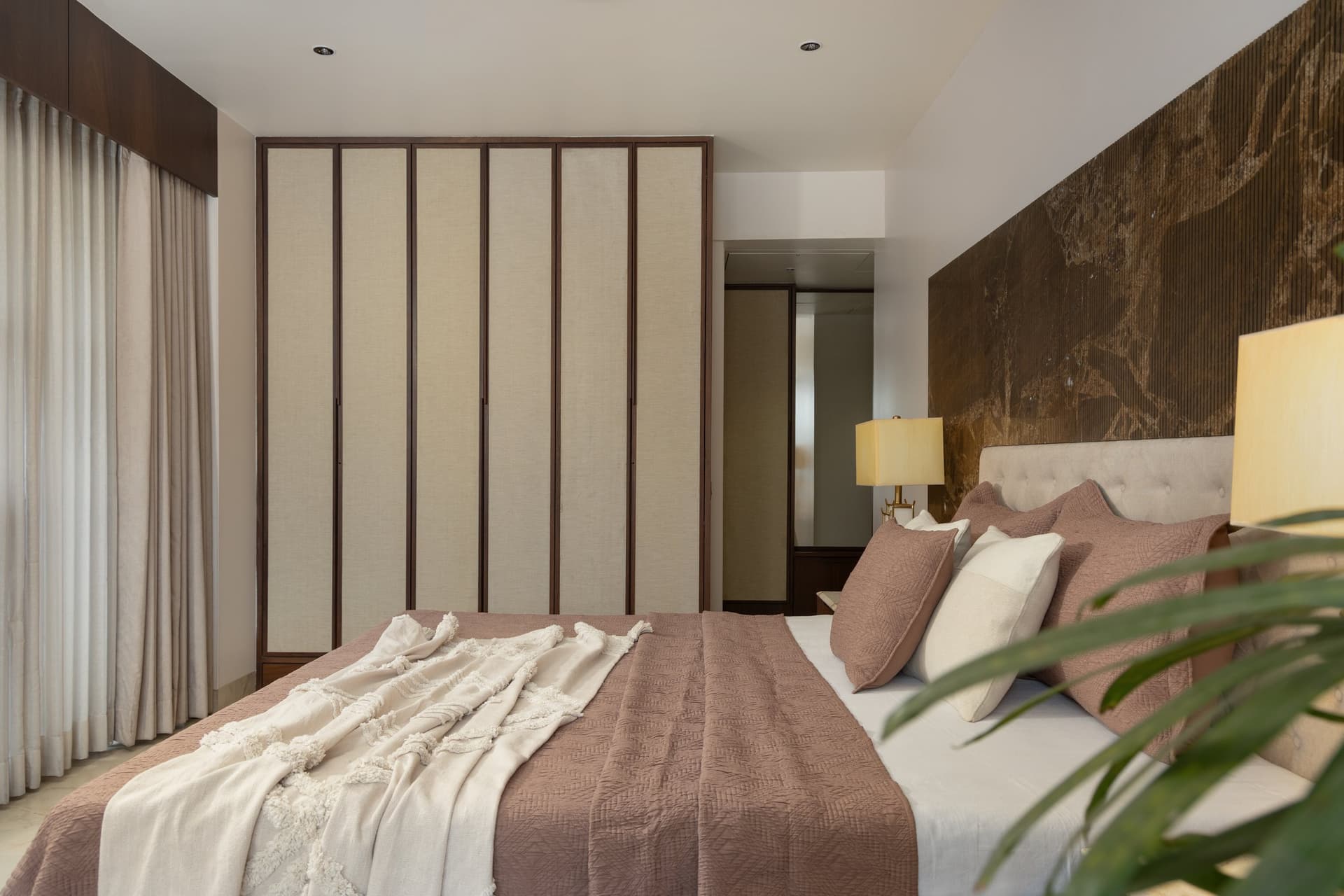 The opposite side of the master bedroom, where linen-panelled wardrobes treat storage as joinery