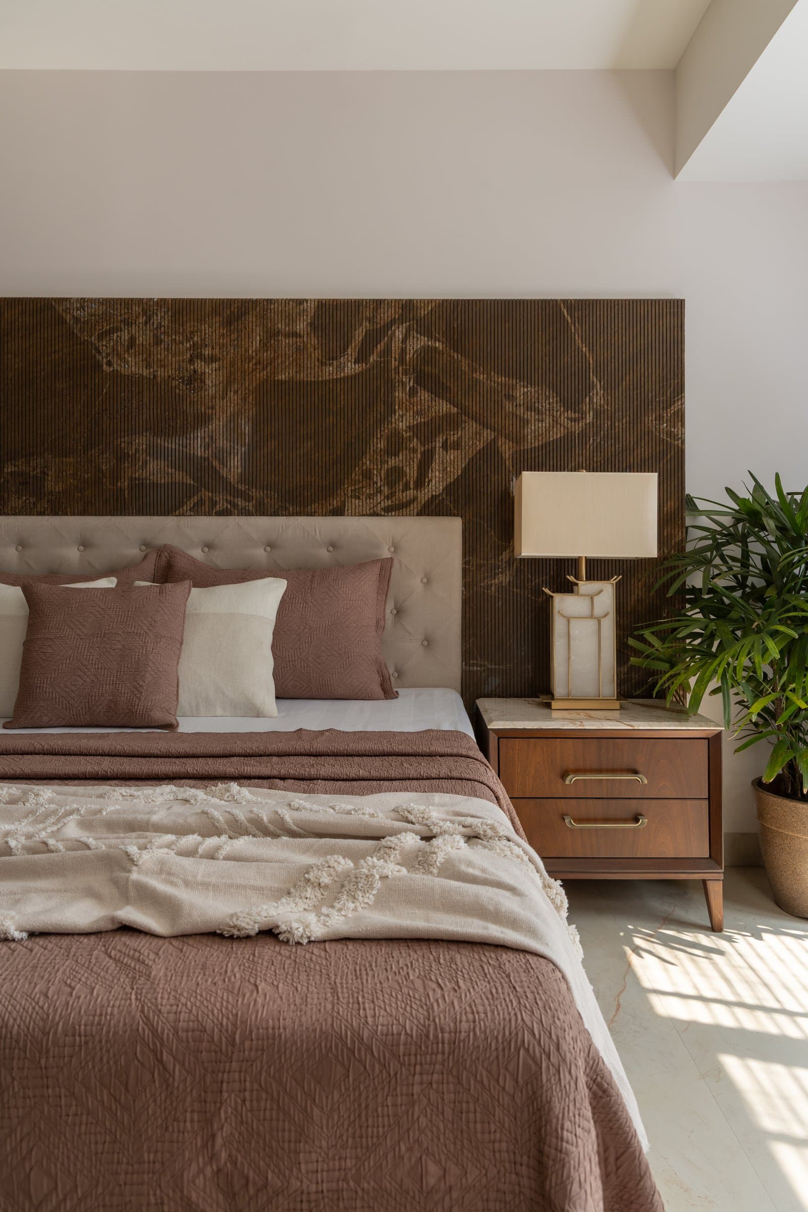 A closer view of the master headboard, where fluting and a bronzed patinated surface share the same plane