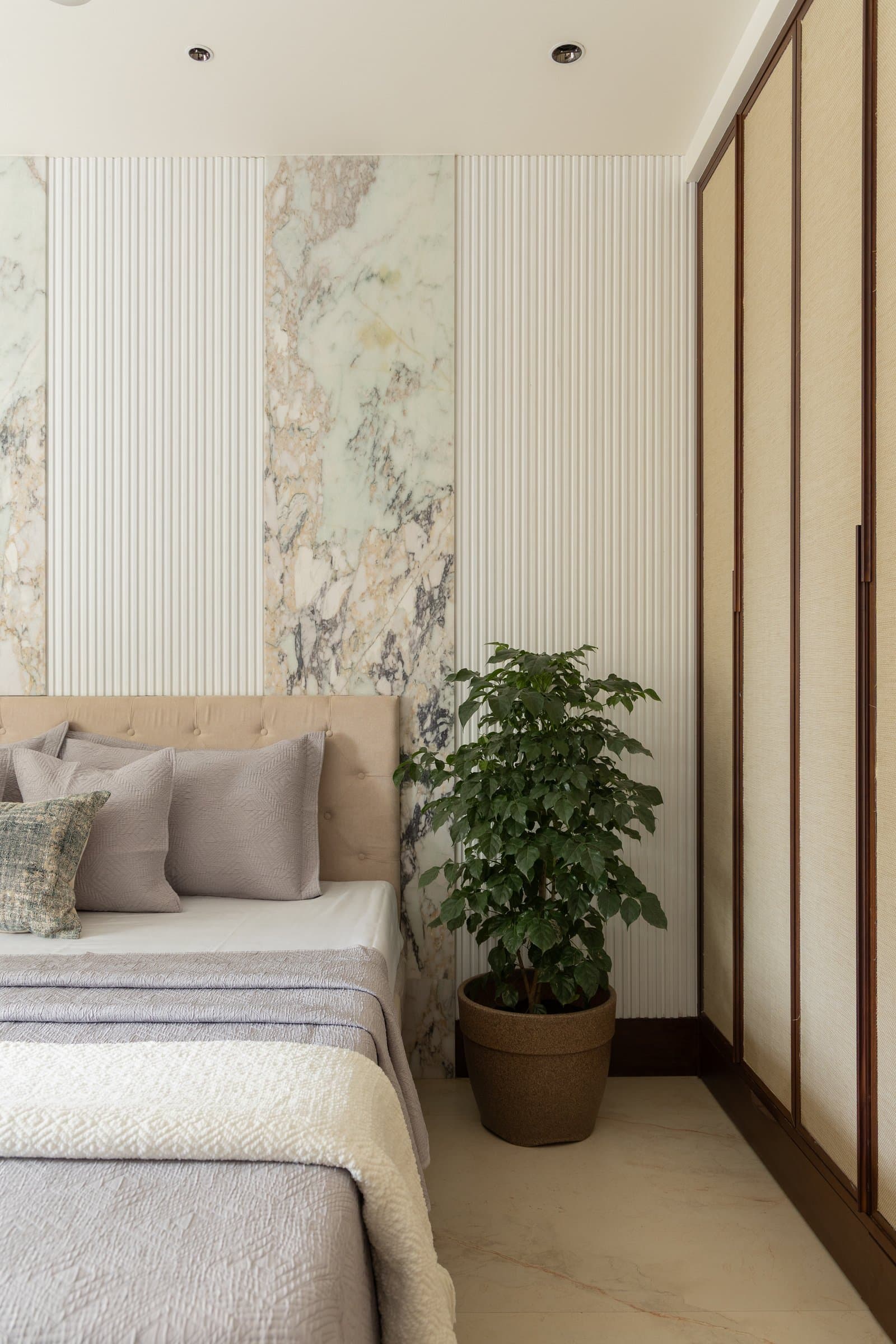The same wall extending into fabric-inset wardrobe doors, the room making its case through proportion alone