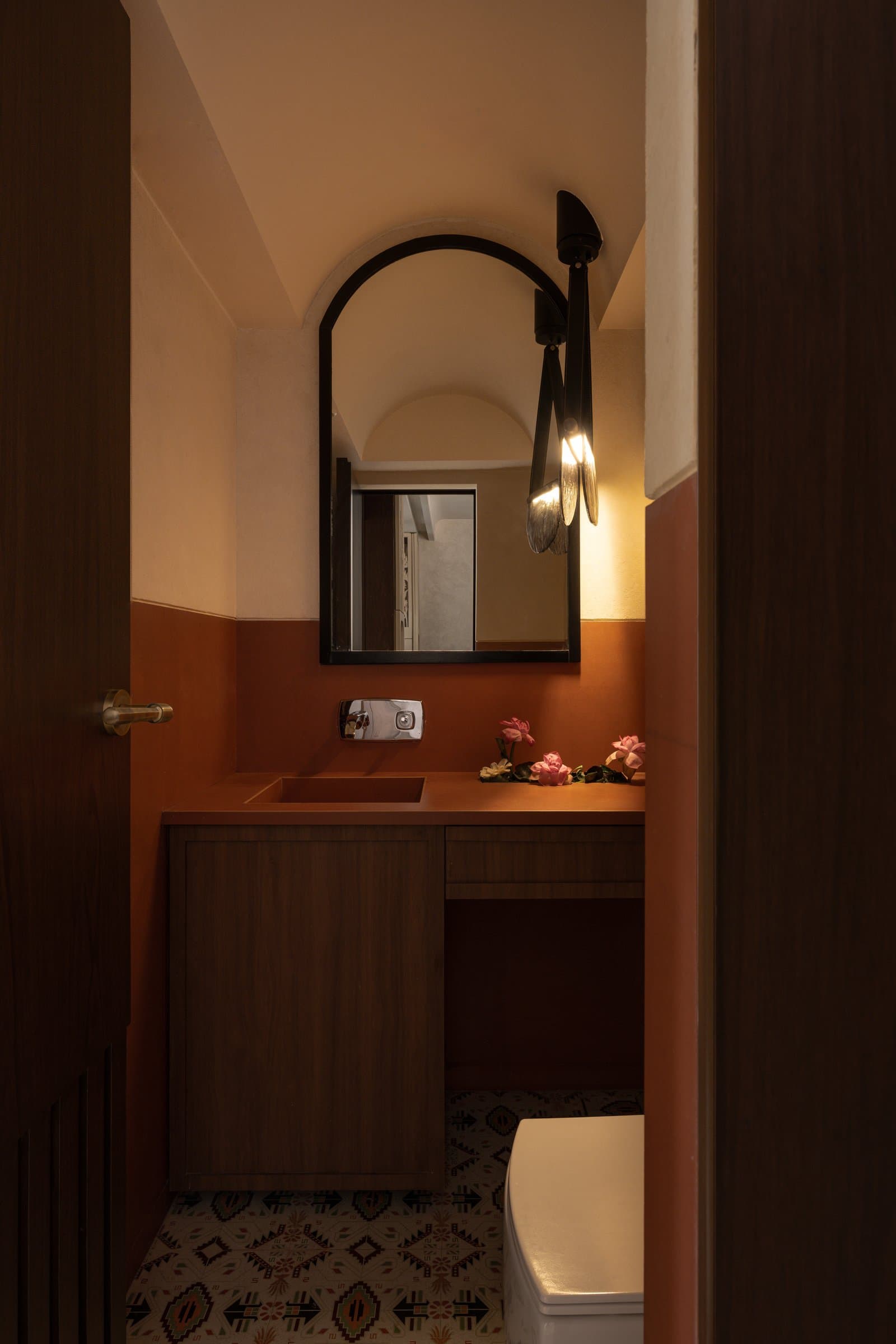 The second bathroom, where mauve tile and a sculptural fluted basin establish a quieter, denser mood