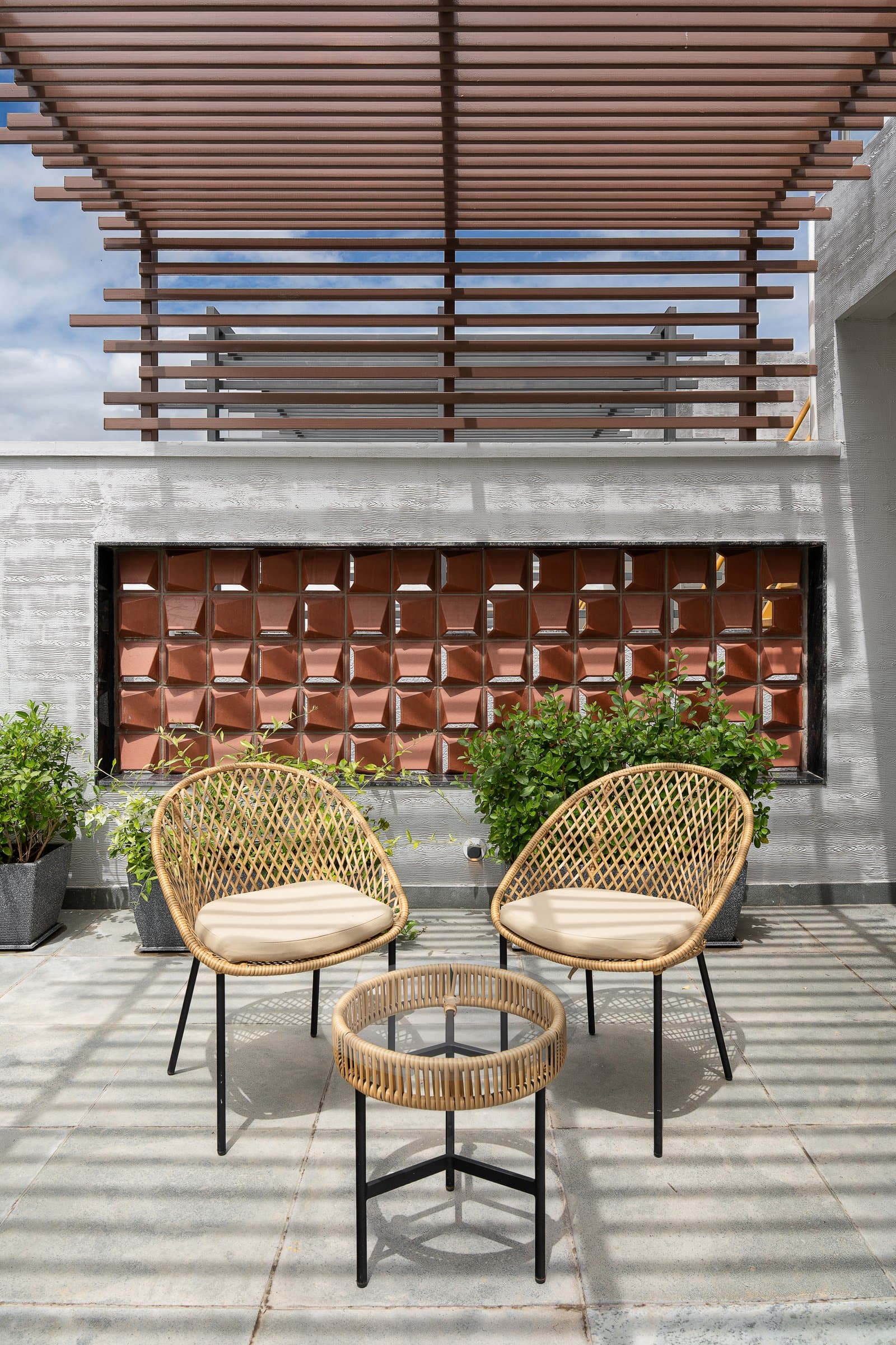 The terrace, where a slatted pergola and a recessed terracotta jaali introduce the home's only outright traditional reference