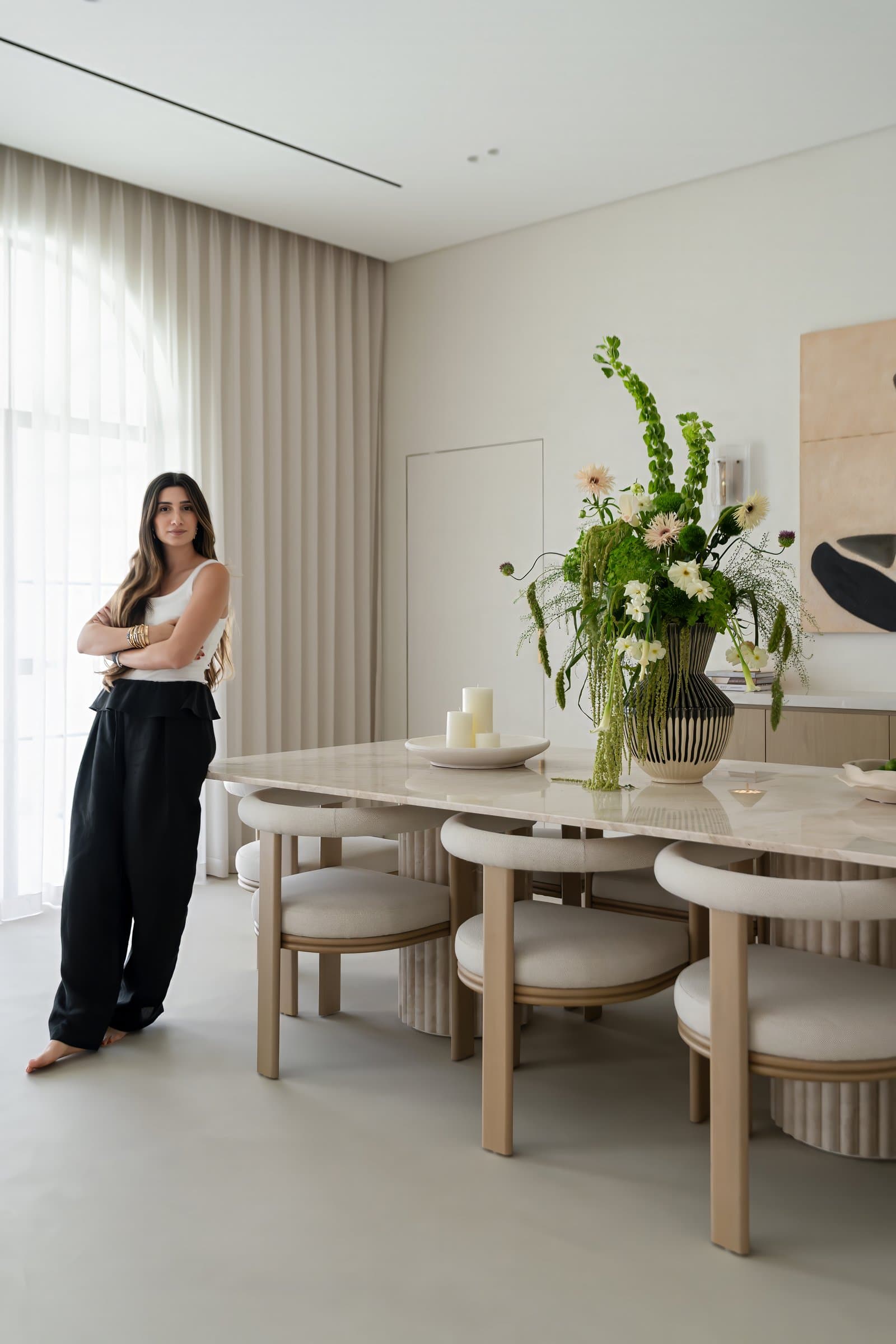Jessica Khouzami of AHI Interiors at the custom travertine dining table