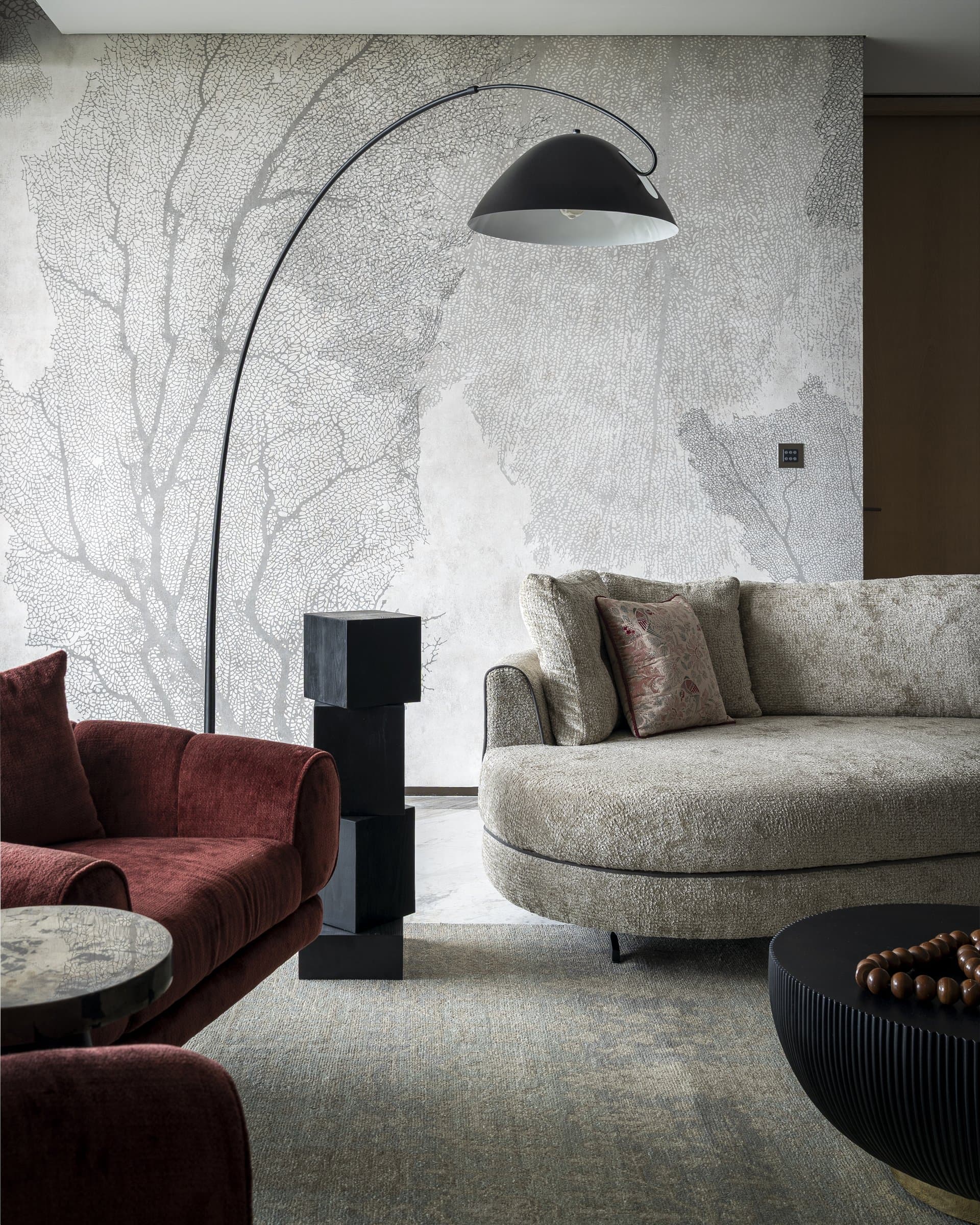 The coral-motif mural behind the curved boucle sofa: the coast referenced, not depicted