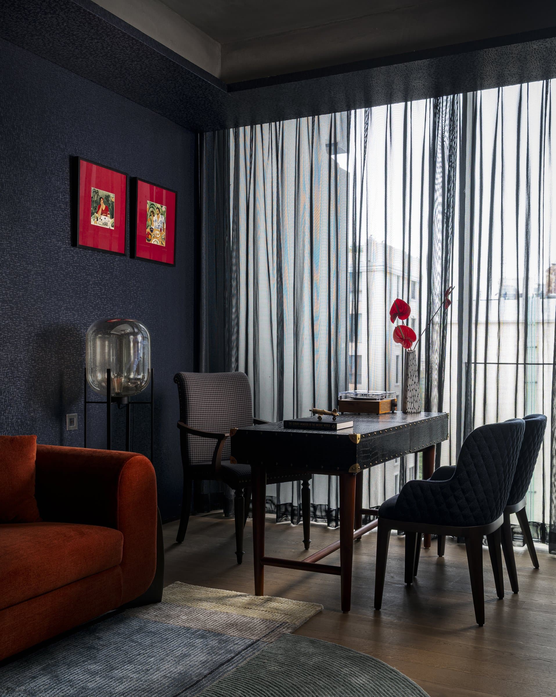 The study, the apartment's one truly dark room, with ink-blue walls and a leather-clad writing desk