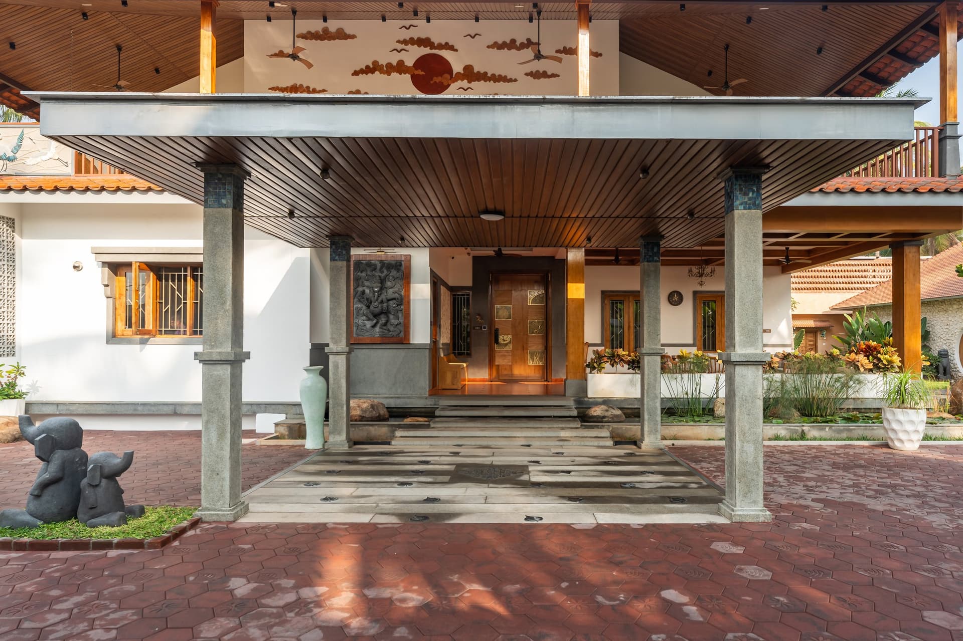 The porte cochère, where a carved sun-and-cloud relief and squared stone columns set the home's ceremonial register