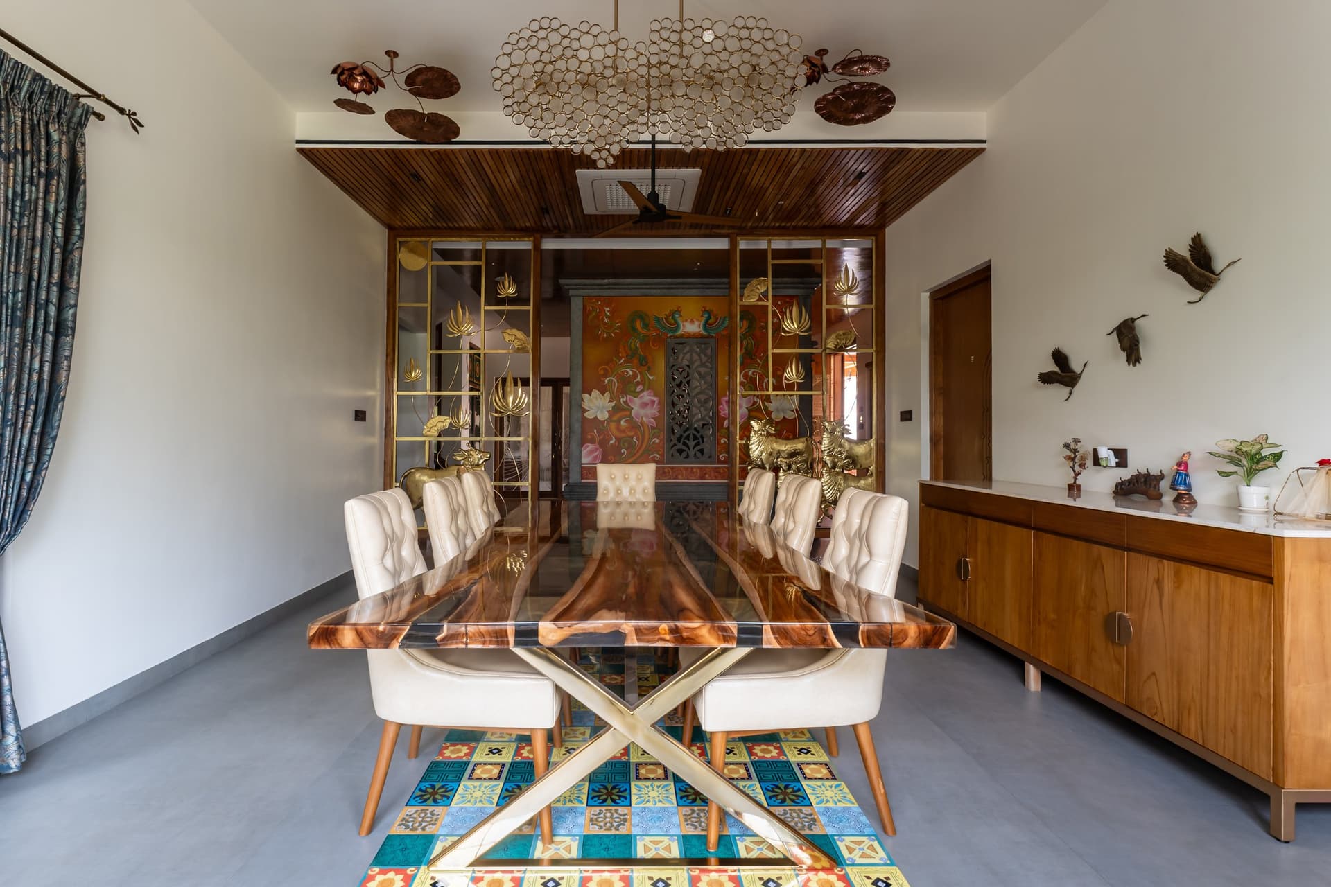 The dining room, where a live-edge timber table sits atop hand-painted encaustic tiles in ochre and cobalt