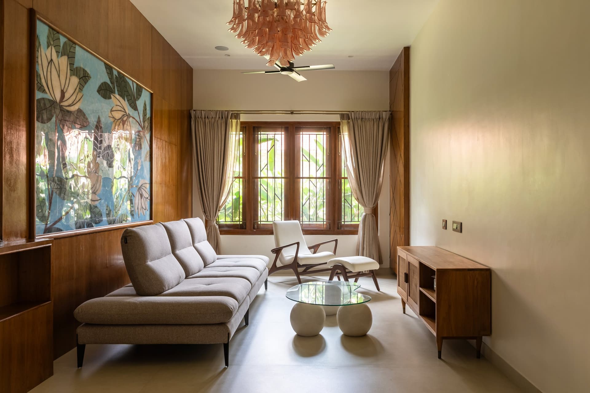The formal living room, anchored by a botanical painting against warm timber panelling
