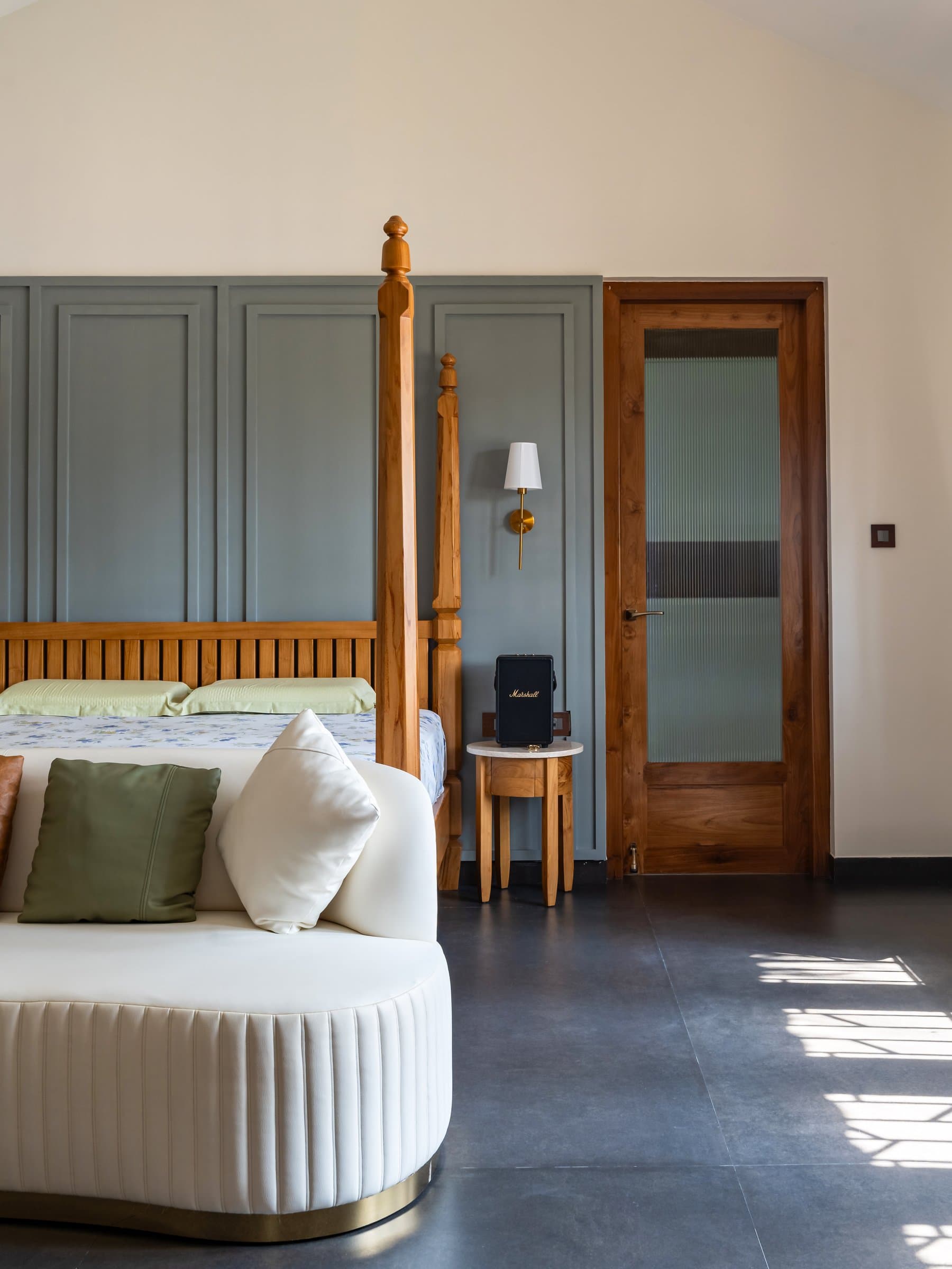 A second bedroom, where a carved timber four-poster meets a panelled sage-green wall