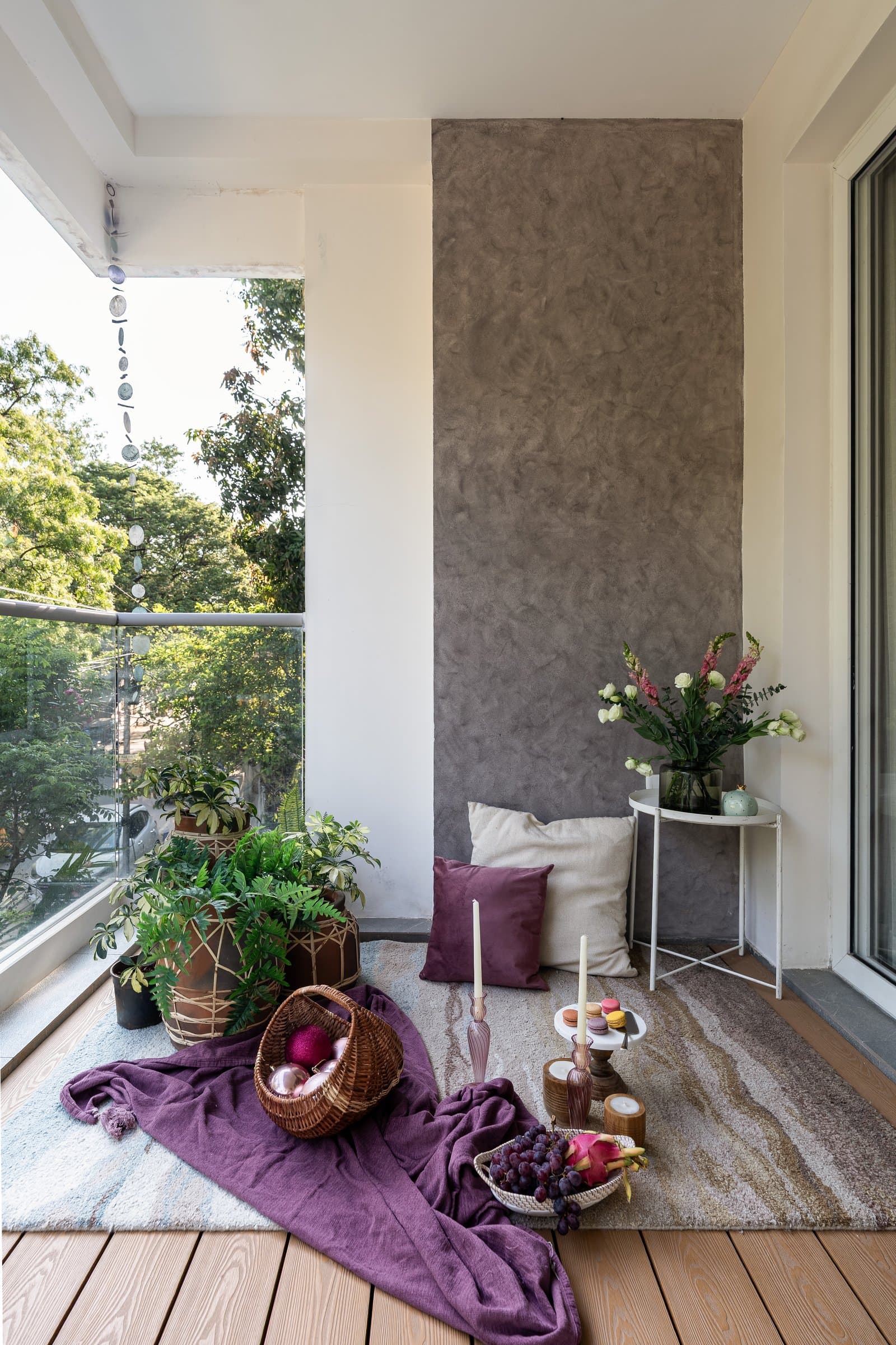 The balcony, a textured taupe plaster panel and warm timber deck configured for the slower rhythms of home