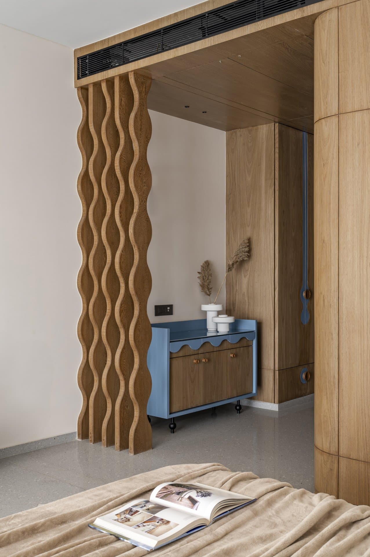 The wavy timber screen and scalloped blue console, marking the transition to the dressing area
