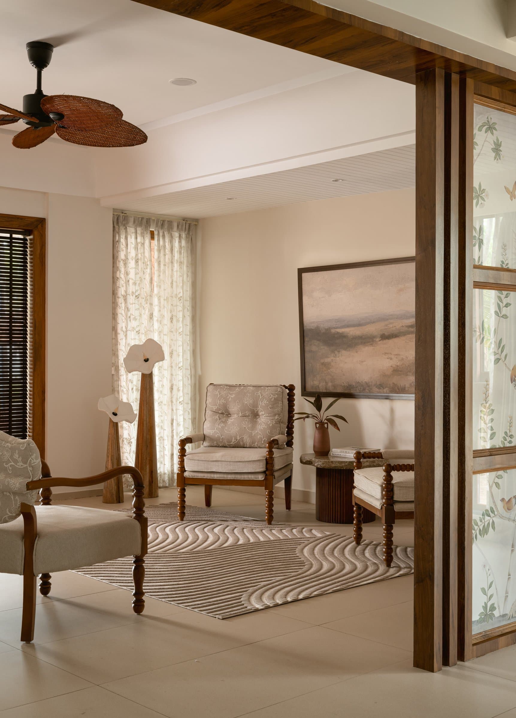 The formal living, where bobbin-turned furniture and a muted landscape painting establish the home's opening pause