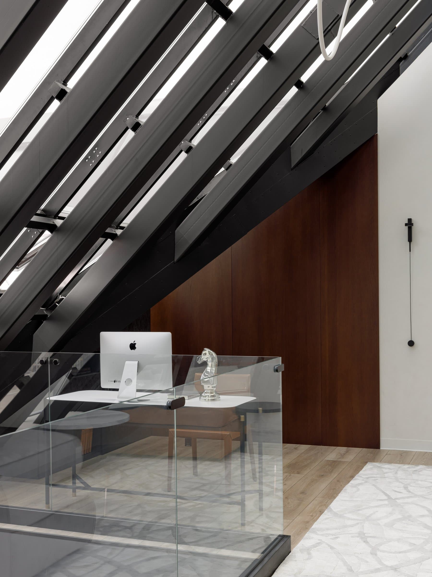 The study nook under the pitched glazed roof, its dark oak backing continuing the palette above