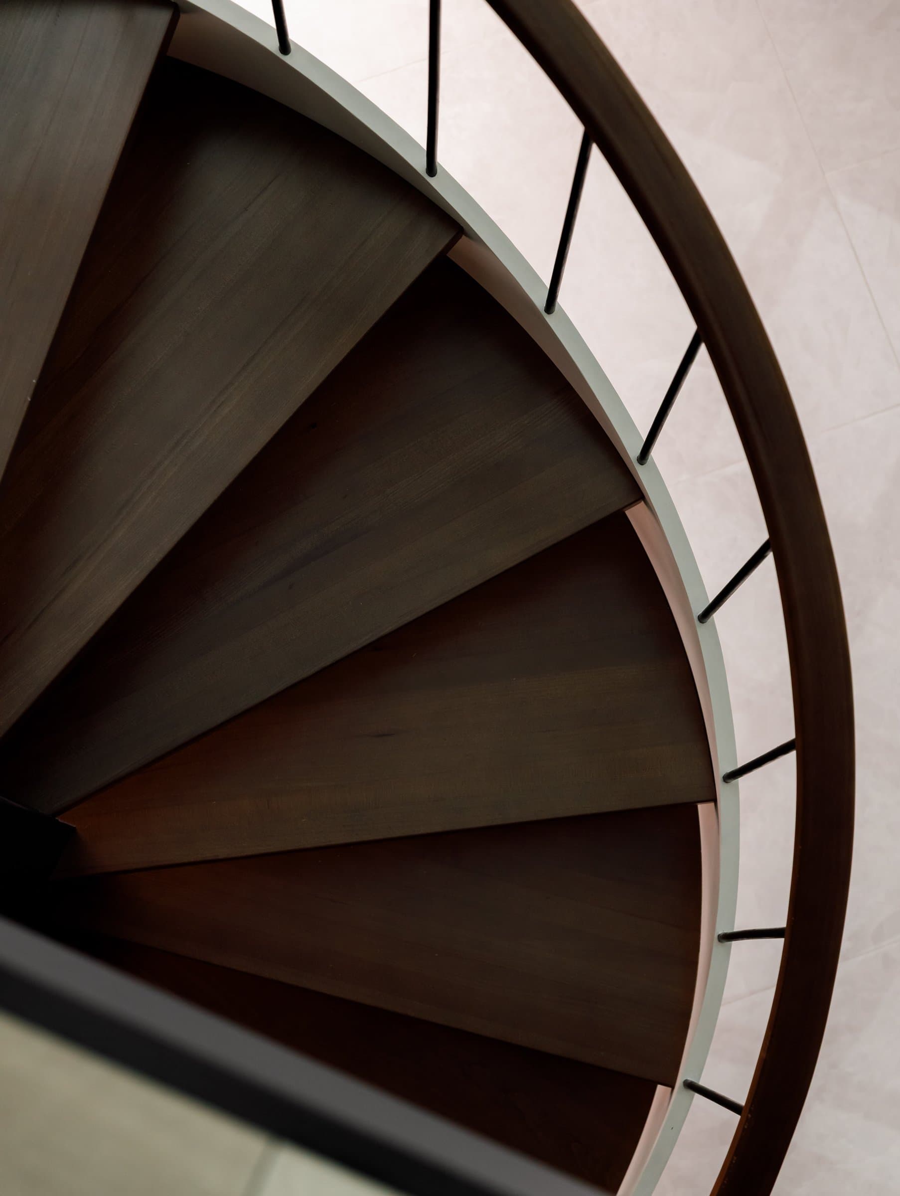 Looking down the spiral, the treads fanning into a soft radial rhythm