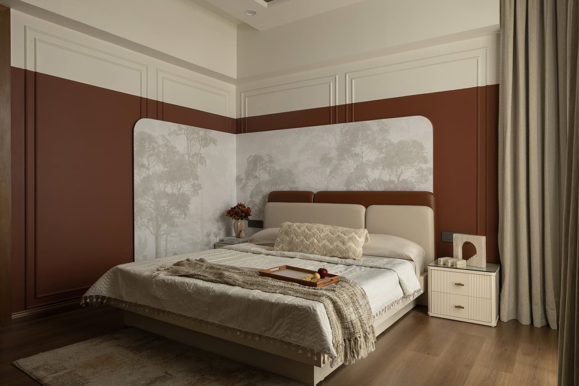The master bedroom, where an oxblood-and-cream two-tone wall meets a curved leather-and-terracotta headboard