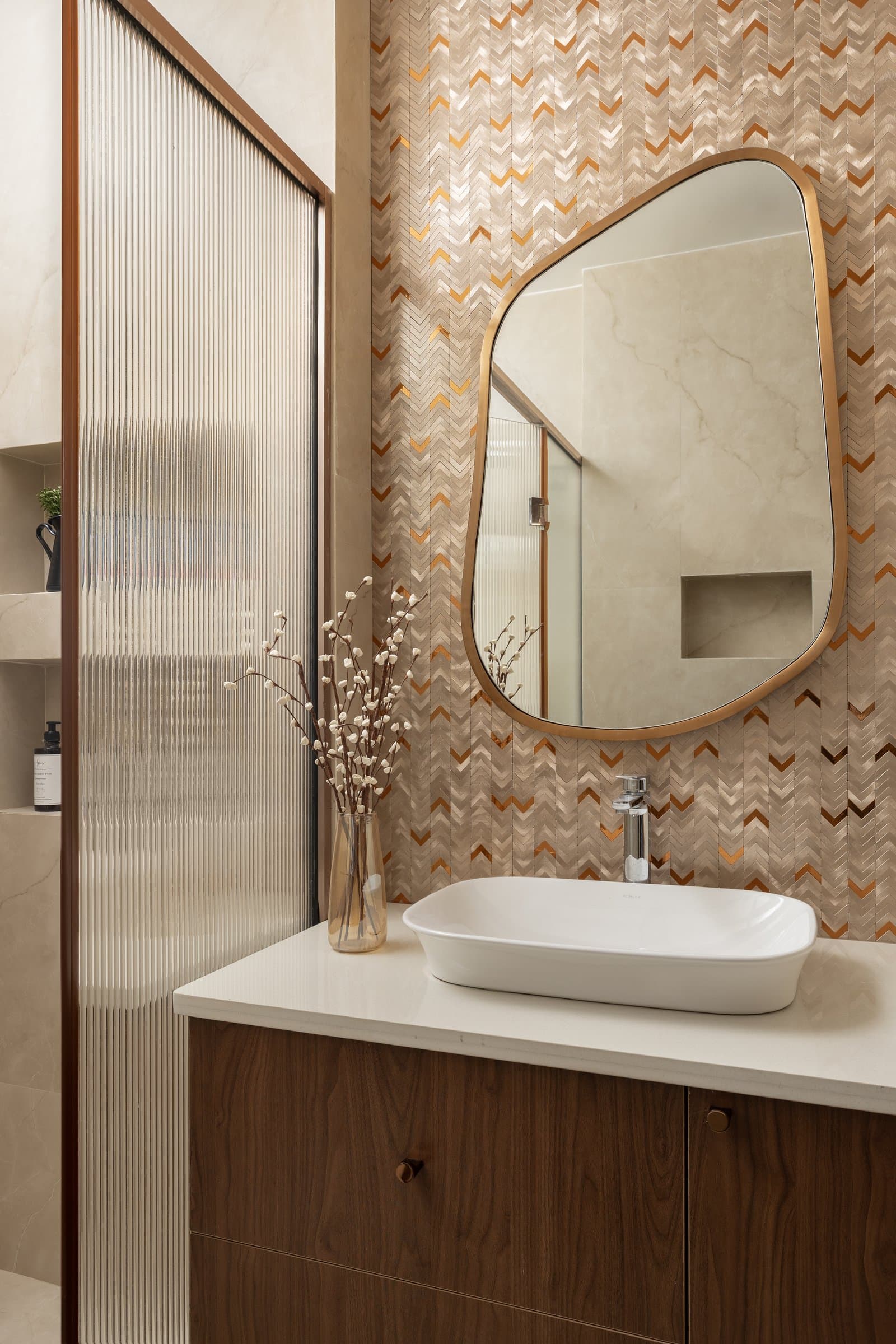 The guest powder room, where a herringbone tile wall with copper inlays meets a walnut vanity
