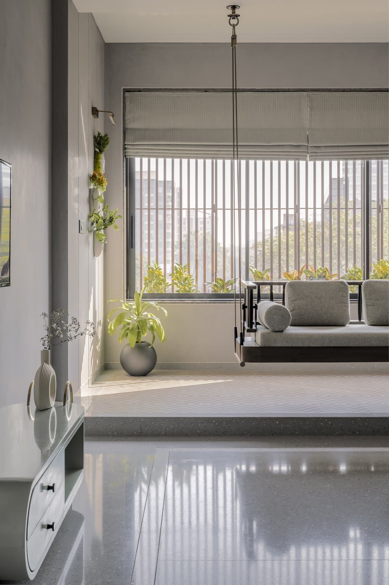The master bedroom, where a cushioned swing faces a slatted timber-screened window