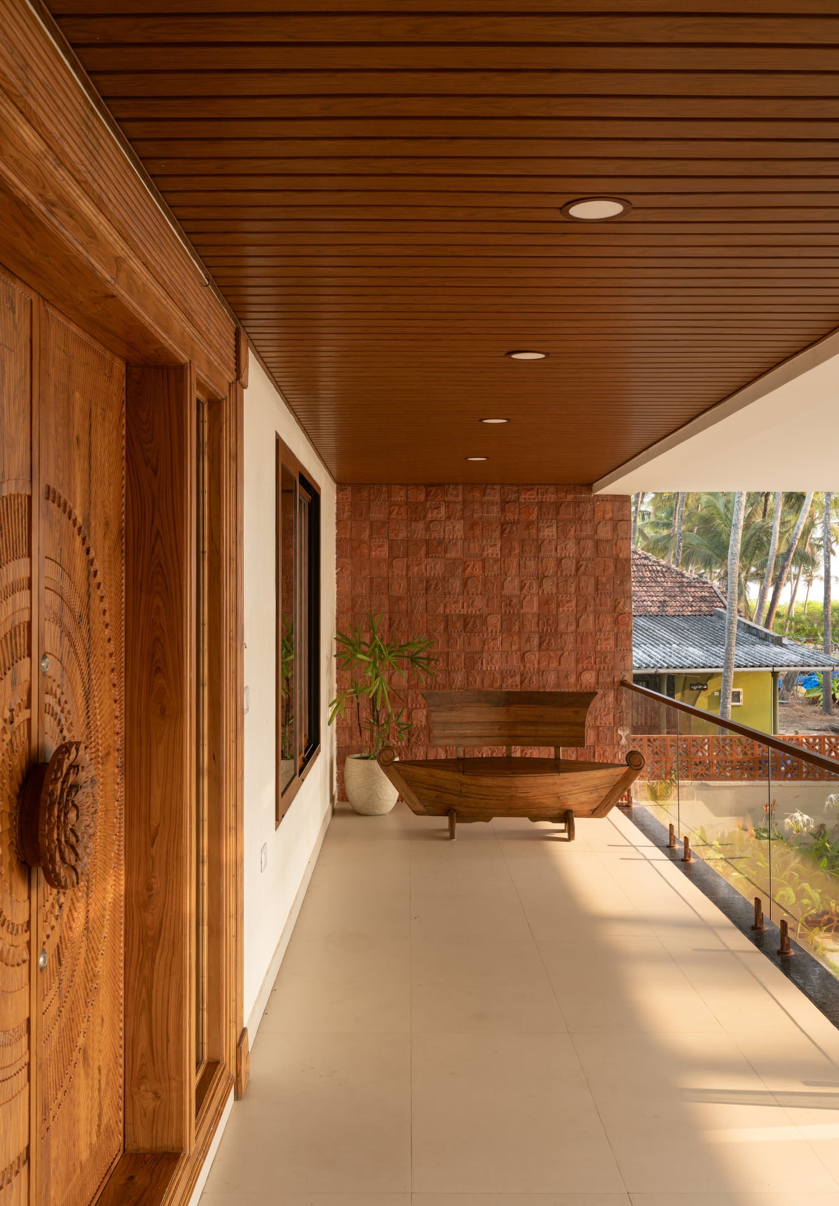 The patio, where a fishing-boat bench sits against a stamped terracotta relief wall