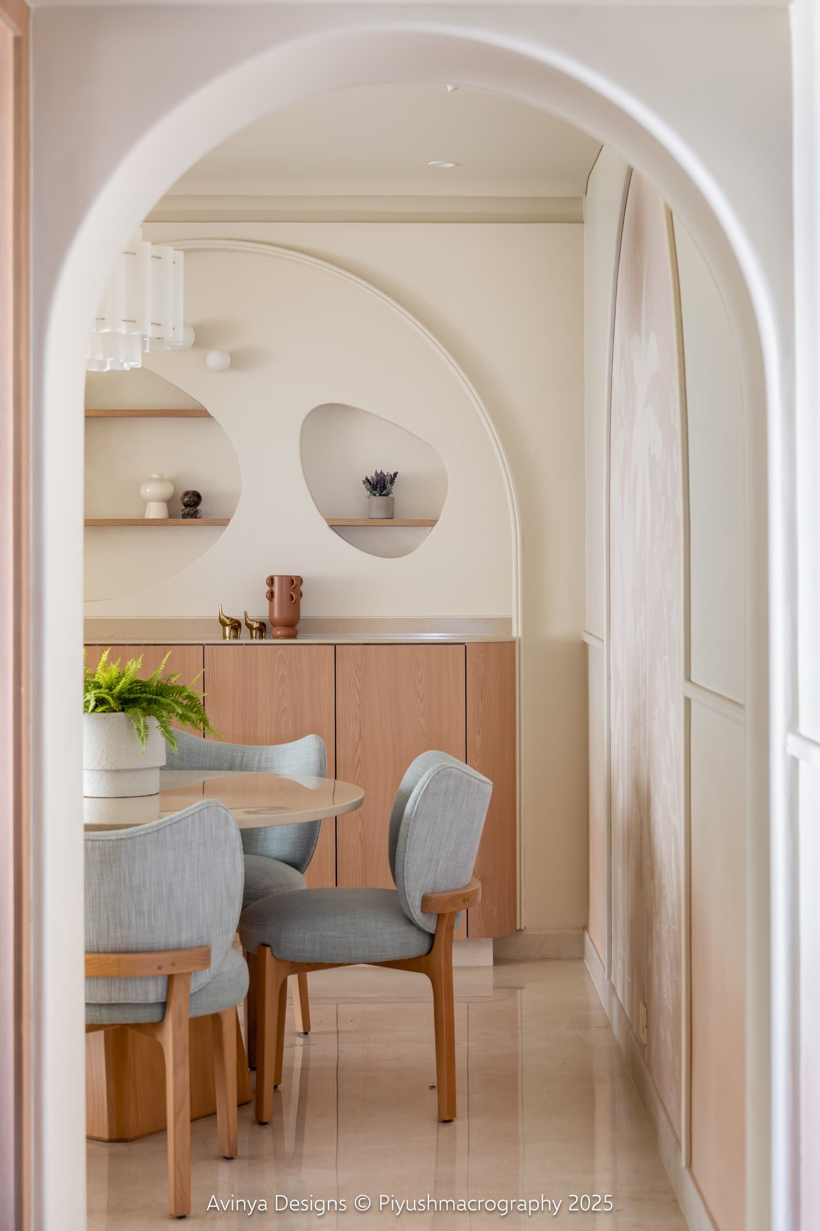 The dining nook seen through the passage arch, framed as an alcove within the home's spatial sequence