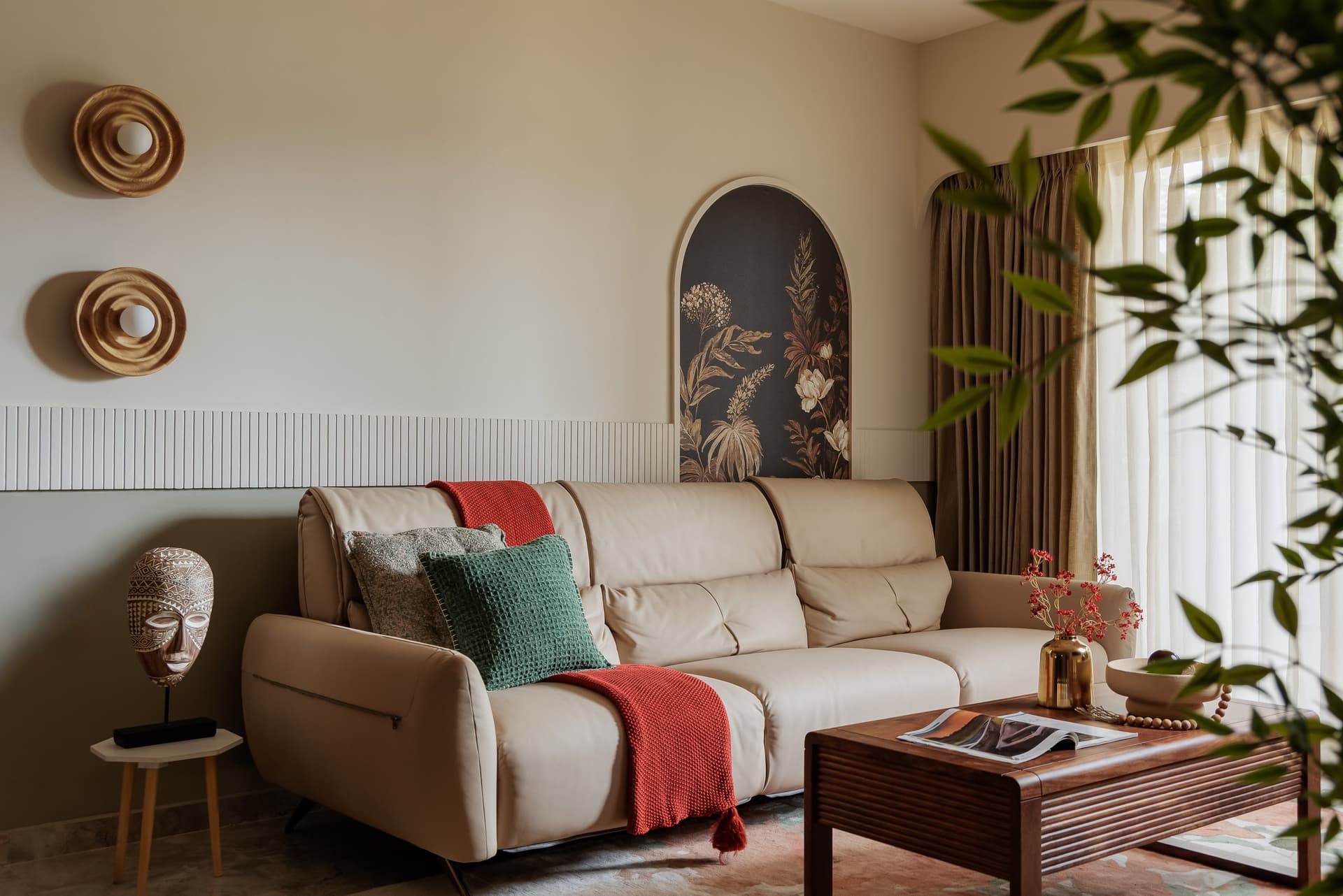 The seating arrangement, where a pale leather sofa sits against a fluted panelled wall softened by a green wash below