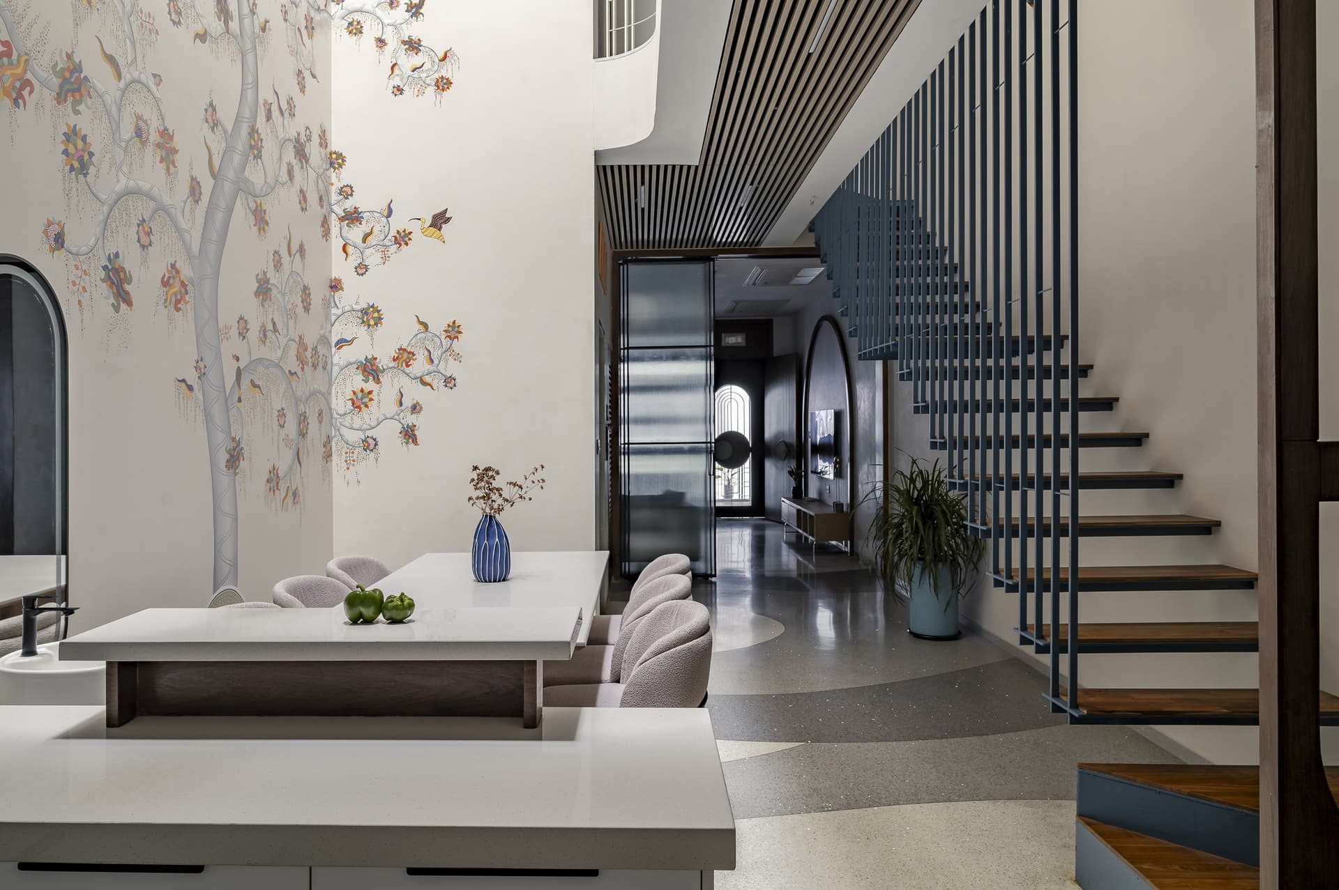 The passage from the kitchen counter toward the arched threshold, unified by wave-pattern terrazzo underfoot