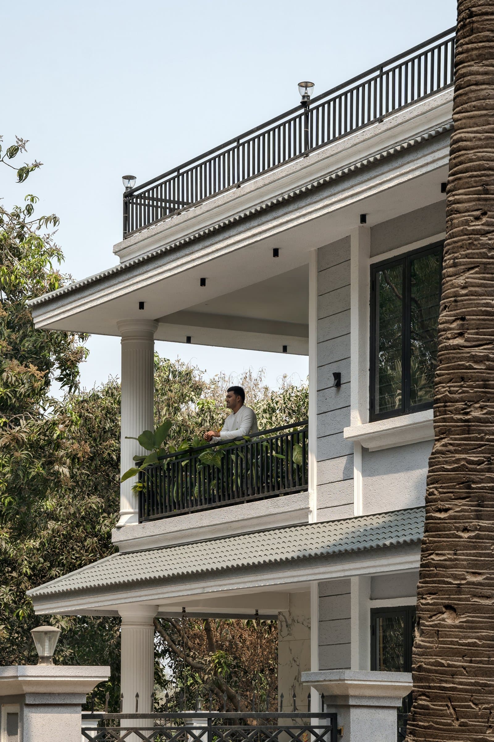 The tiled eave, a quiet reference to Kerala's sloped-roof tradition translated into a compact contemporary silhouette