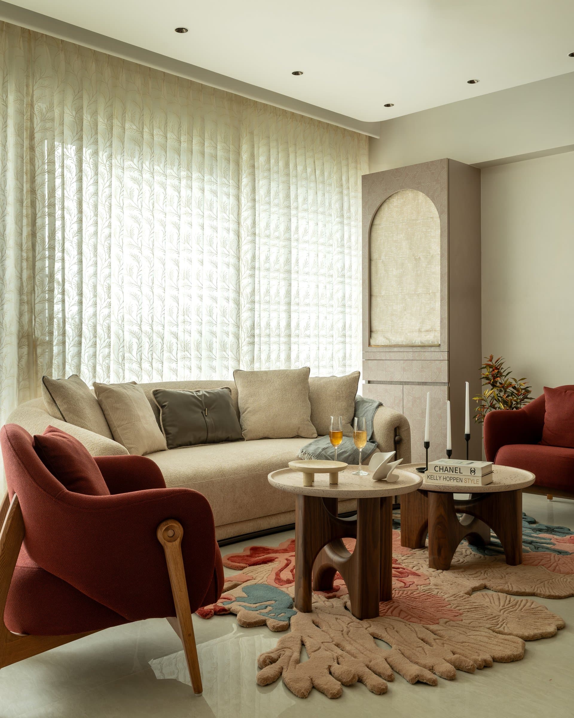 The seating group in the living room, arranged around twin travertine coffee tables on a scalloped rug