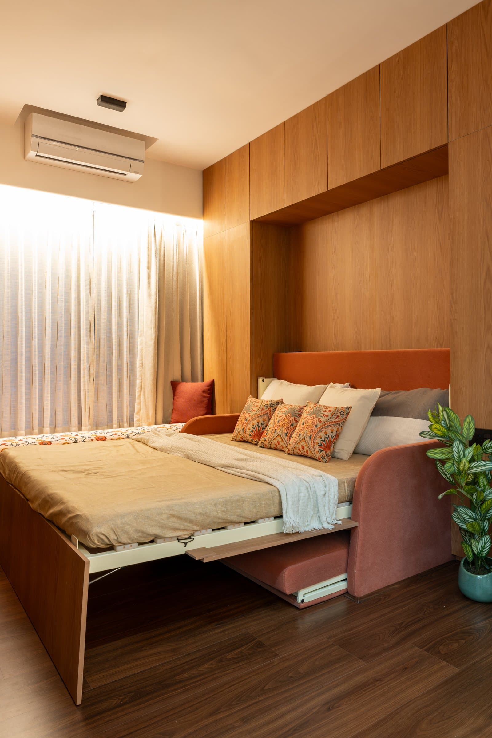 The guest room in Murphy-bed mode, its warm timber joinery opening to reveal a full sleeping surface