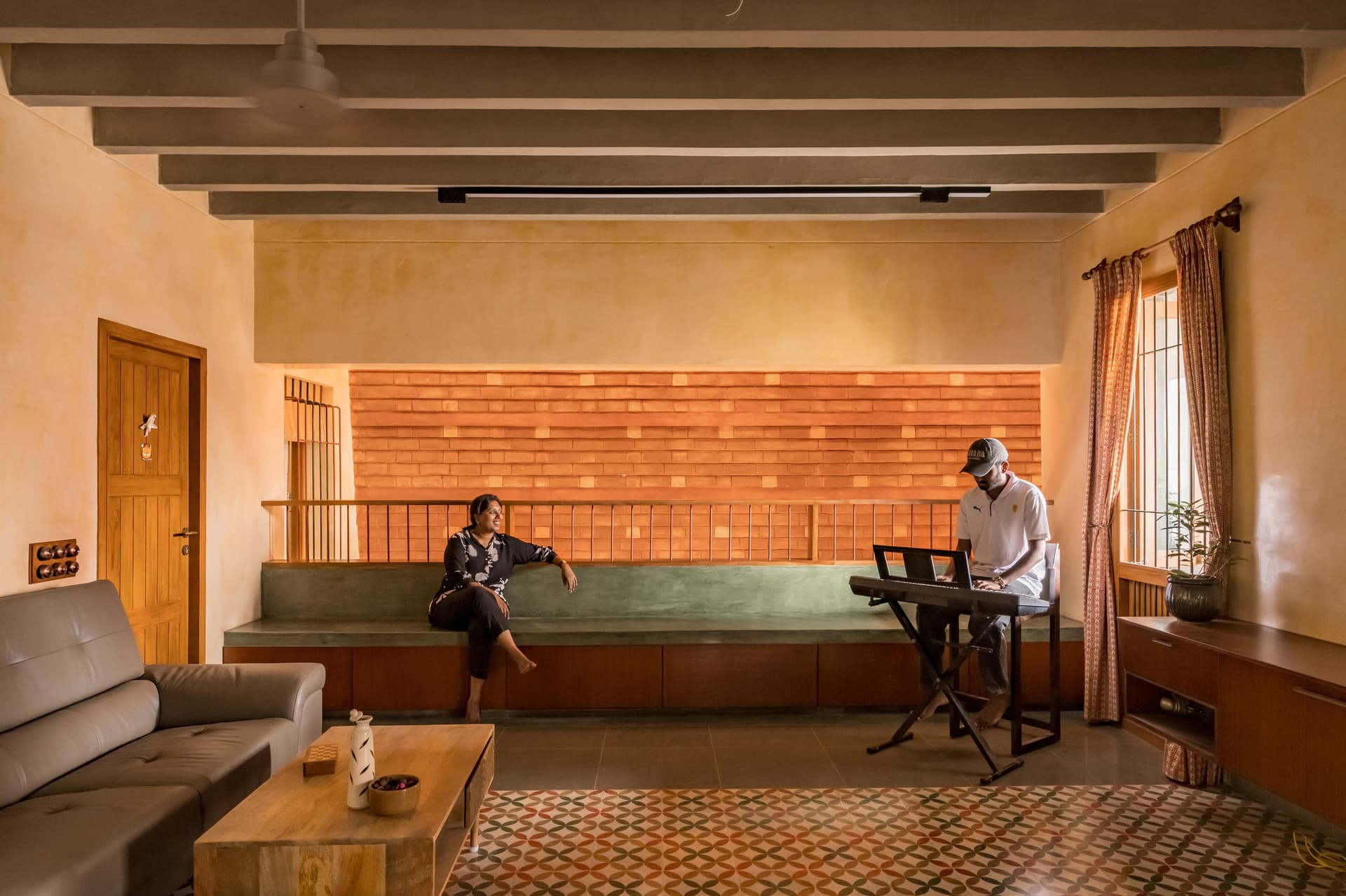 The family room, anchored by a green concrete bench against a protruding brick wall