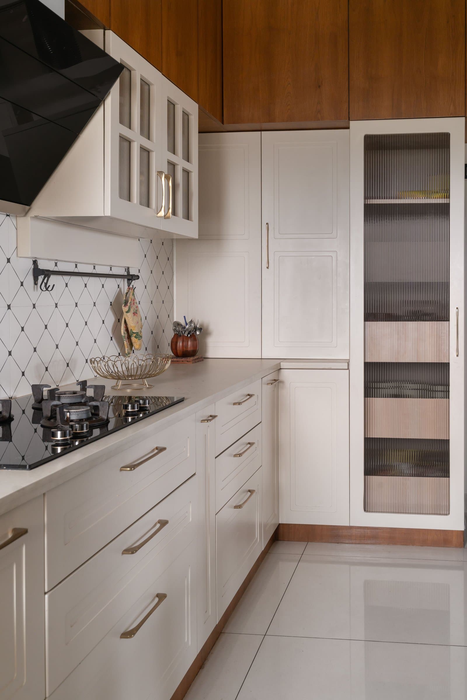 A perpendicular run of the kitchen, where reeded glass tempers the classical raised-panel discipline