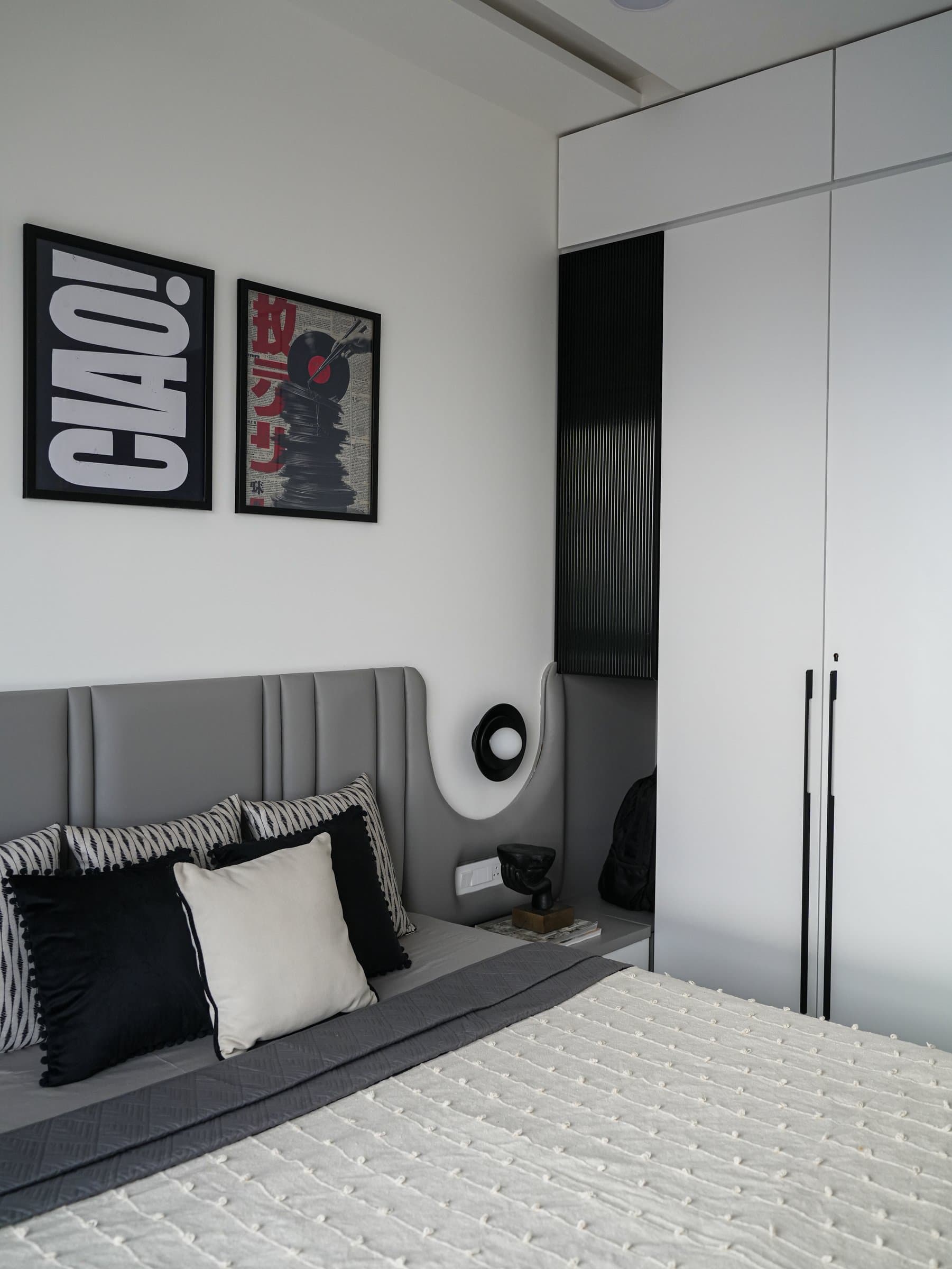 A curved wall detail with a small sconce and niche shelf eases the transition to the full-height wardrobe