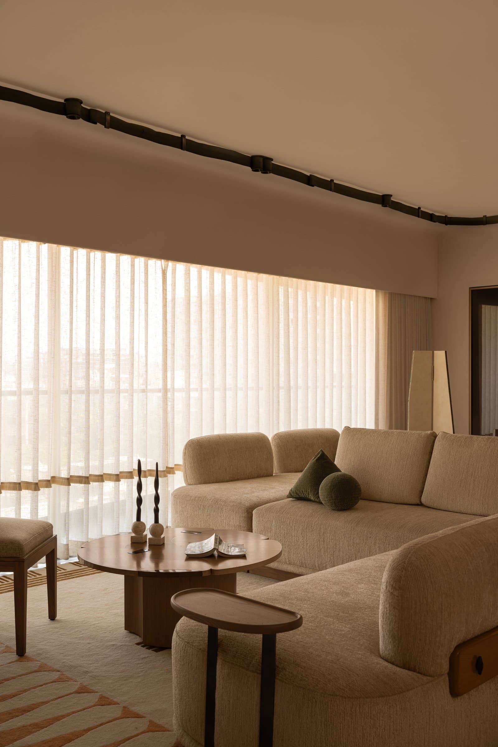 A closer view of the seating arrangement, where boucle upholstery and rounded wooden accents anchor the room's tactile register