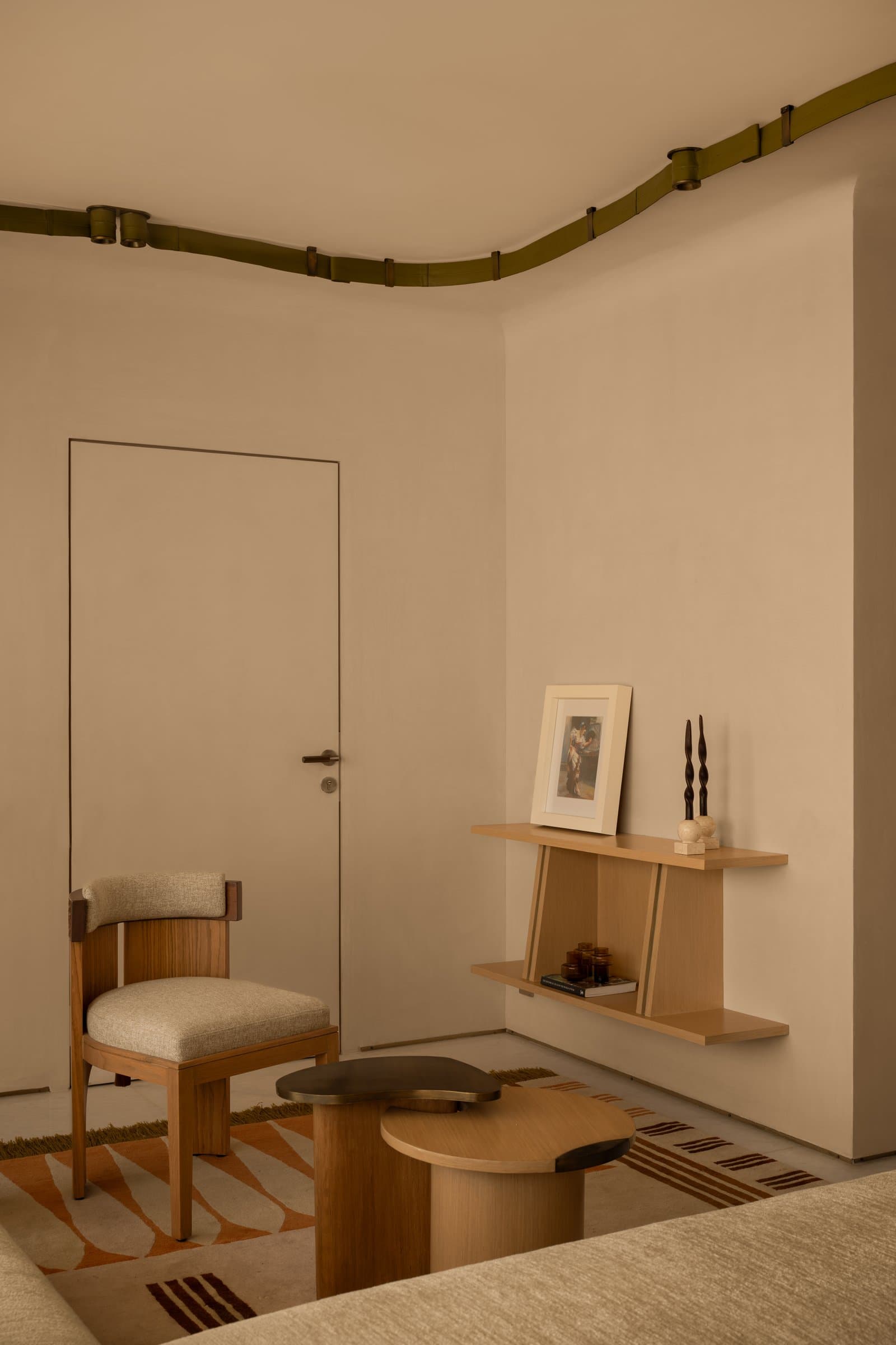 The reading corner, where a floating shelf and a sculptural coffee table create a small zone for pause within the bedroom