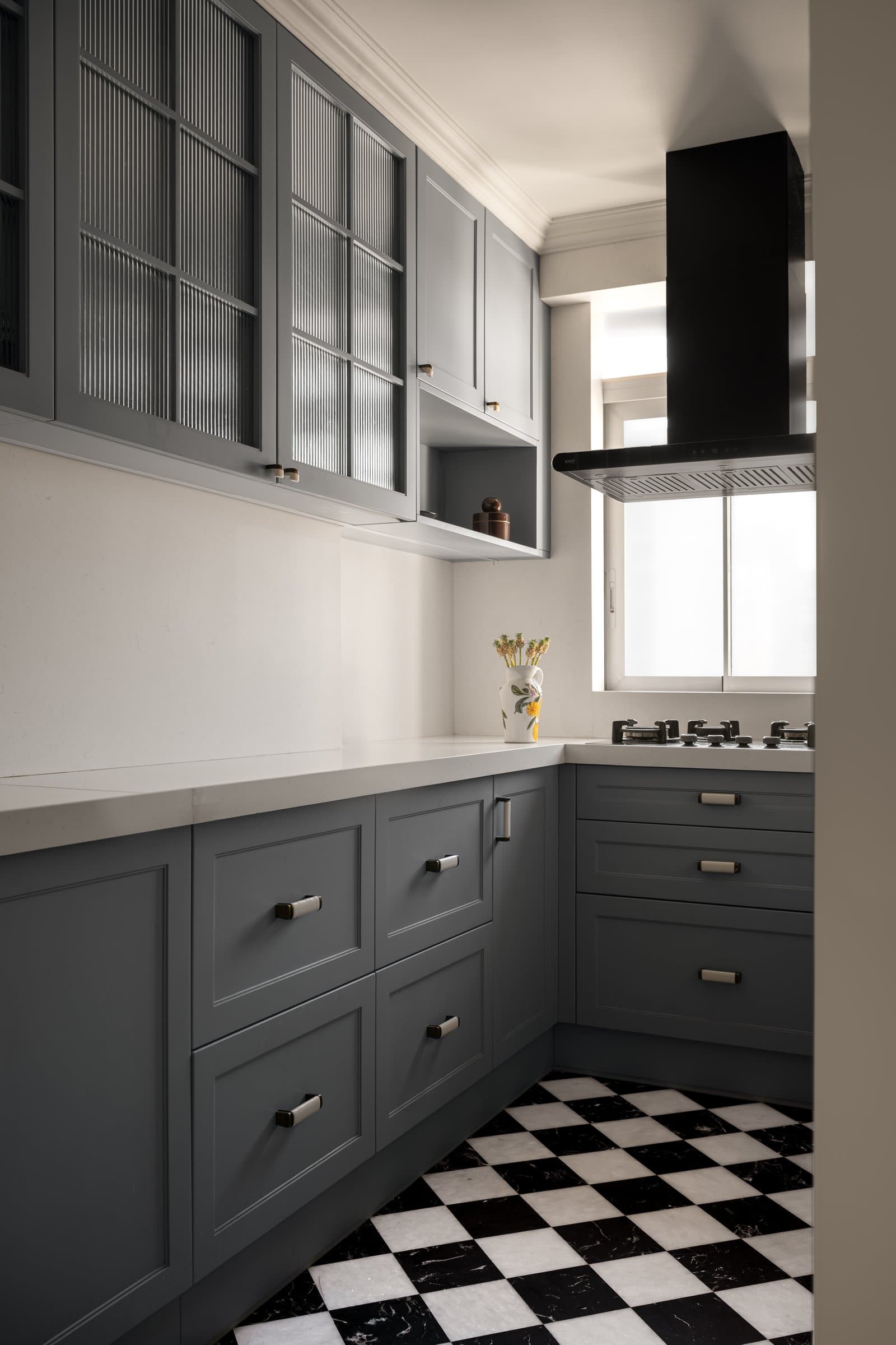 A closer view of the kitchen joinery, where reeded glass fronts and brass-toned pulls soften the disciplined cabinetry