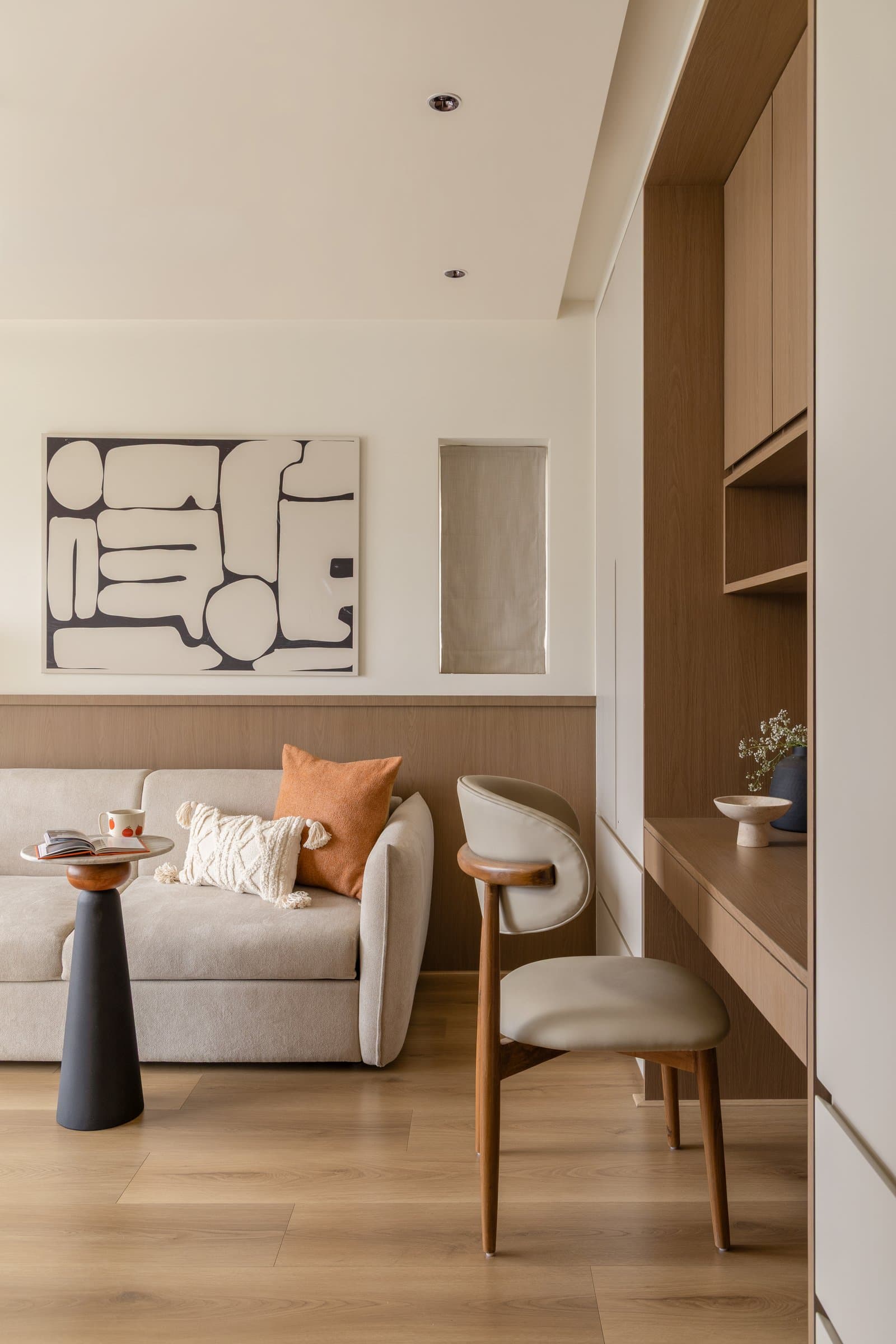 The den, with a compact sofa, timber dado and graphic monochrome artwork