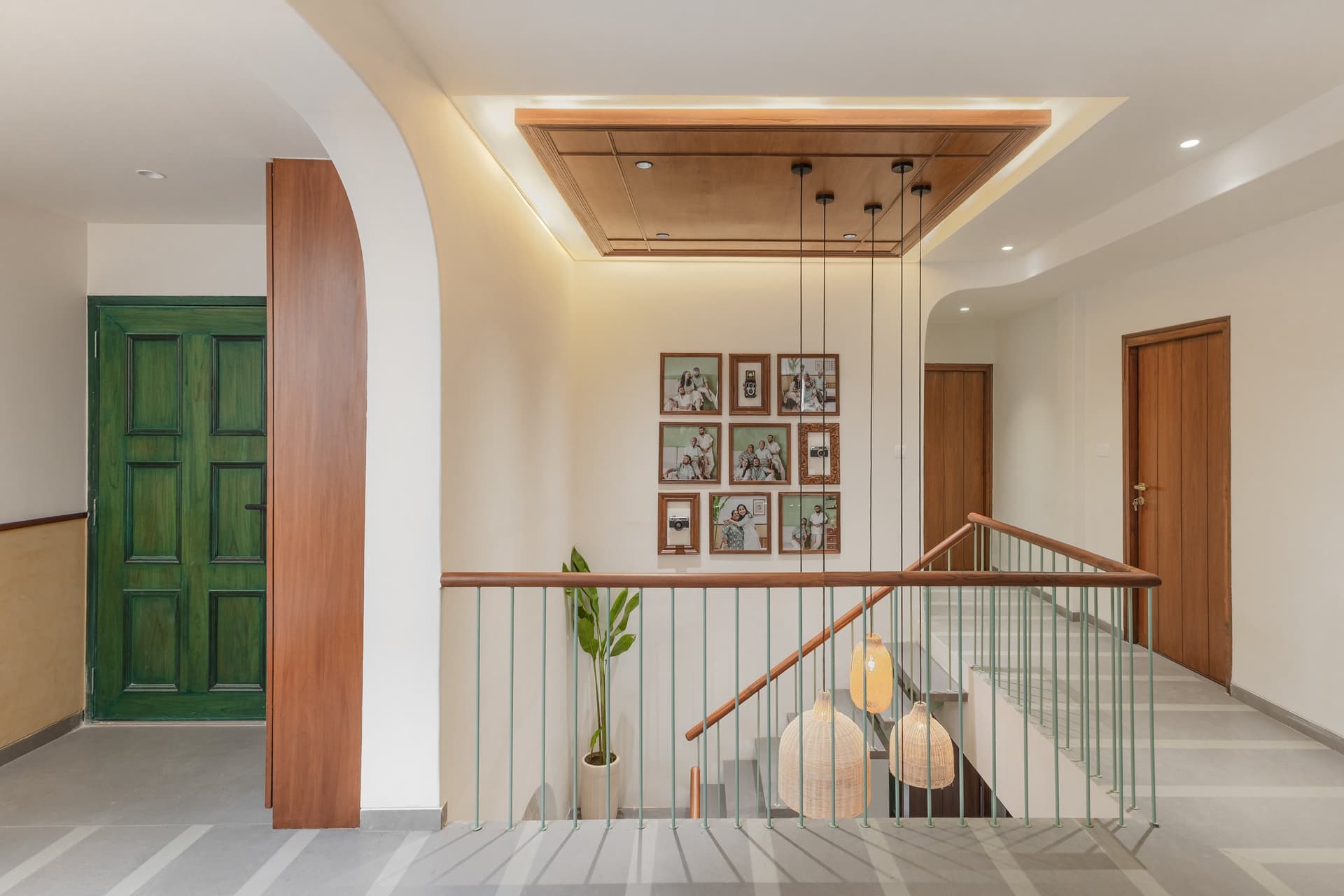 The upper landing, where a family photo wall and a repurposed green painted door layer the home with memory