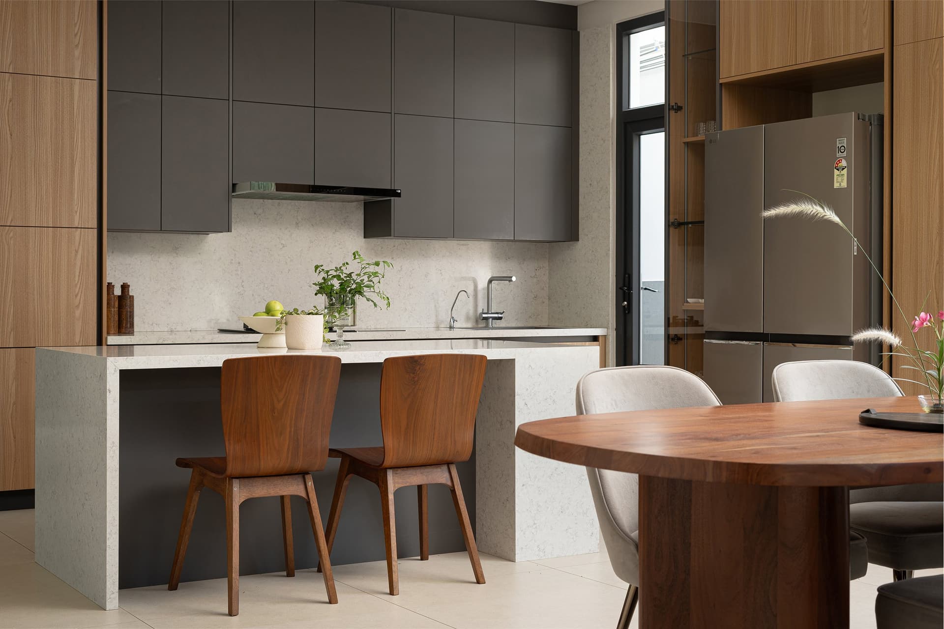 The kitchen’s working counter, with a subtly veined stone backsplash and a slim glazed service door