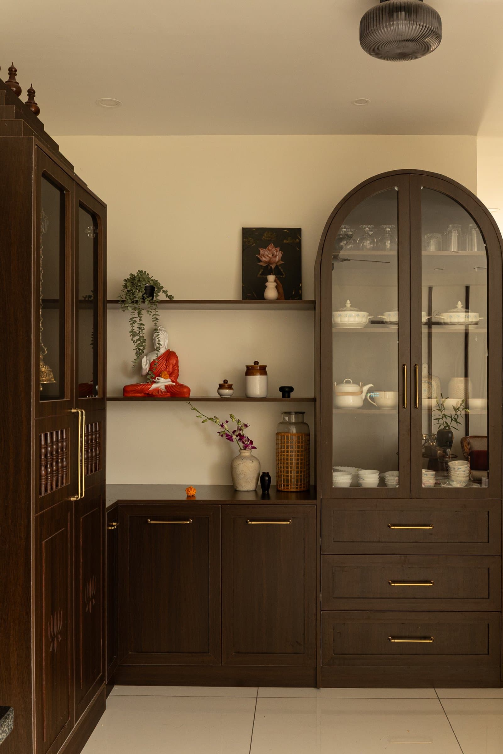 The adjacent crockery cabinet, where an arched glass front softens the room's otherwise rectilinear joinery