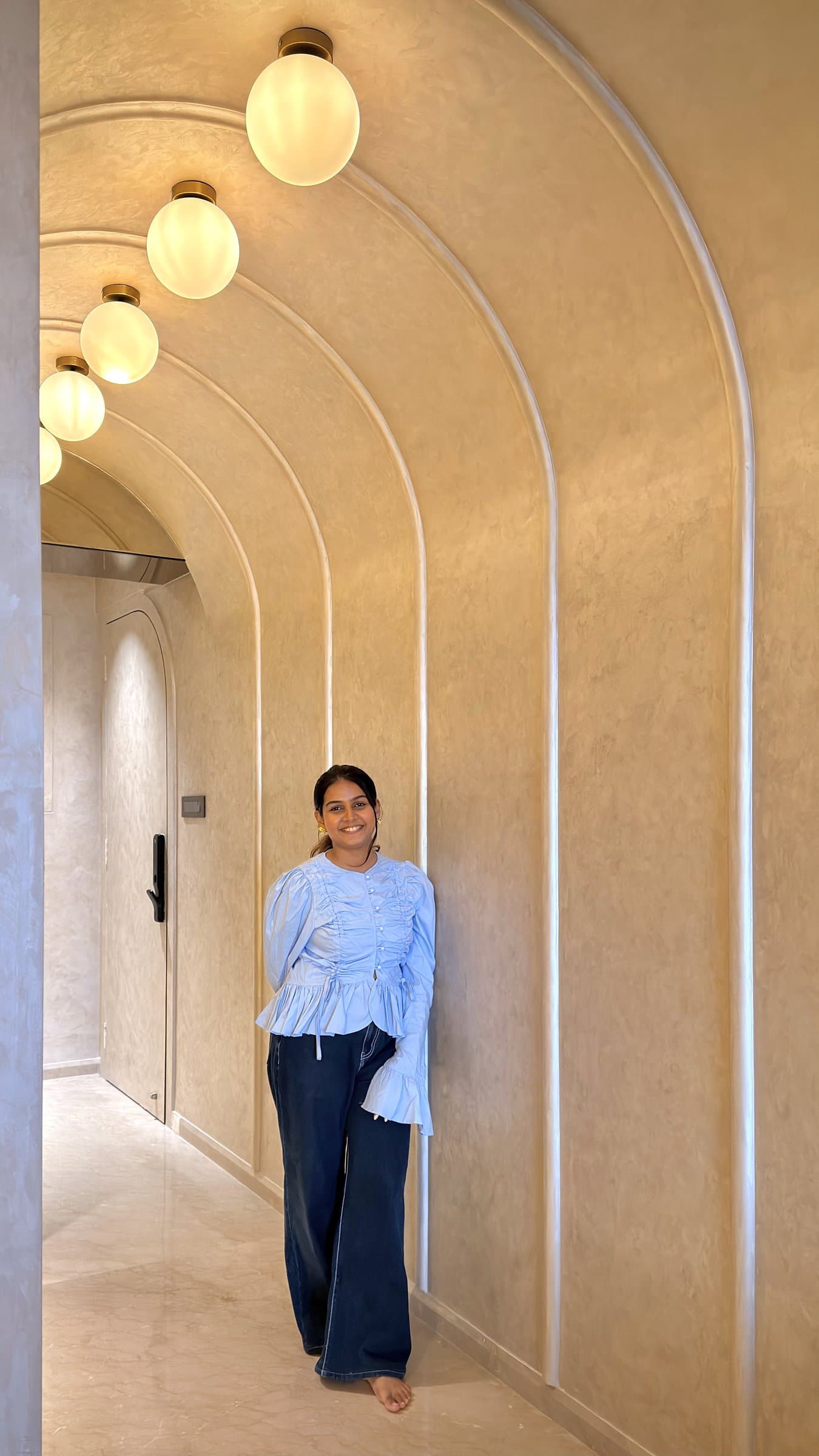 Shikha Shah Mody of Studio Soma, within the home's arched plaster corridor