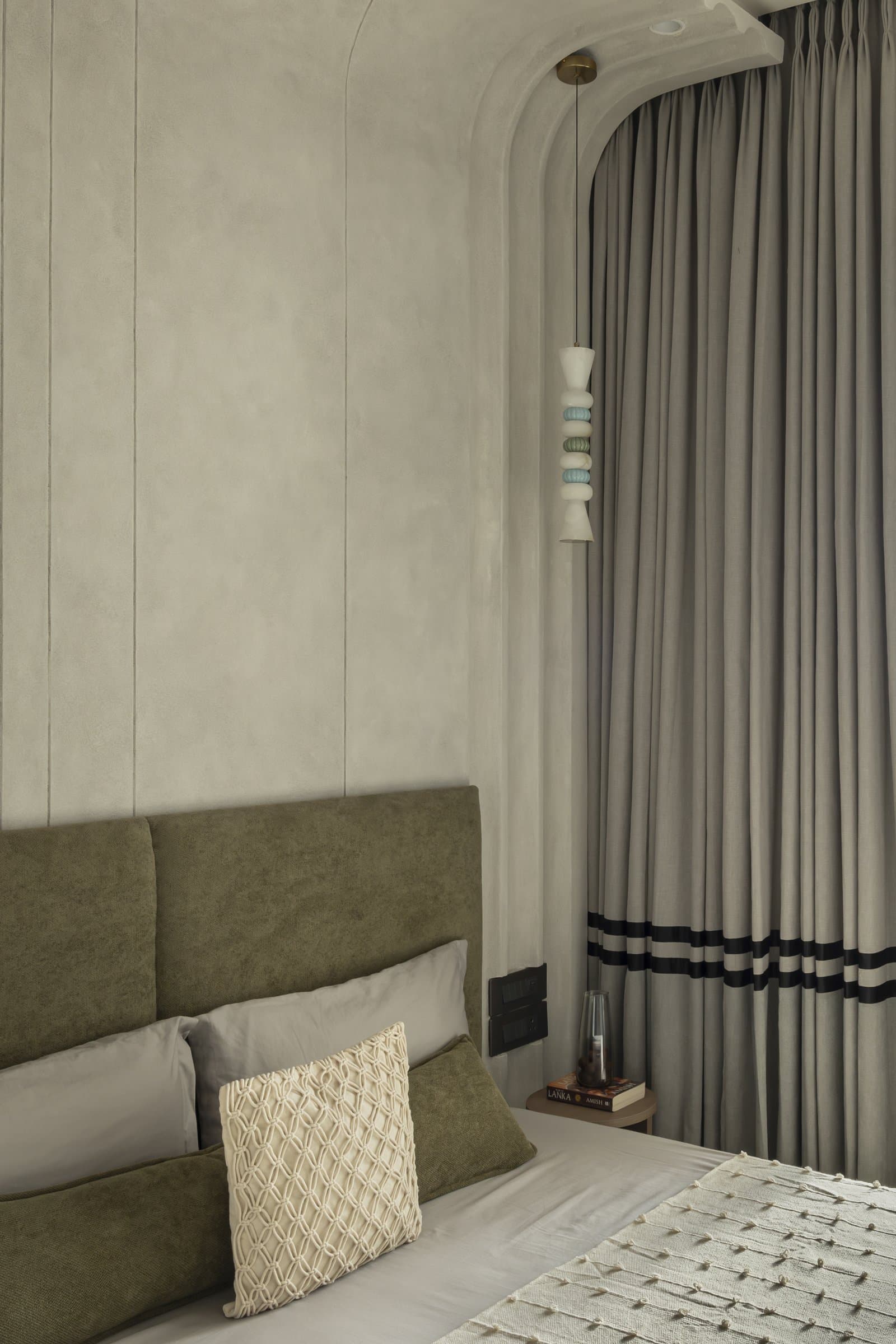 The sculpted beaded pendant hanging beside the room's arched ceiling junction