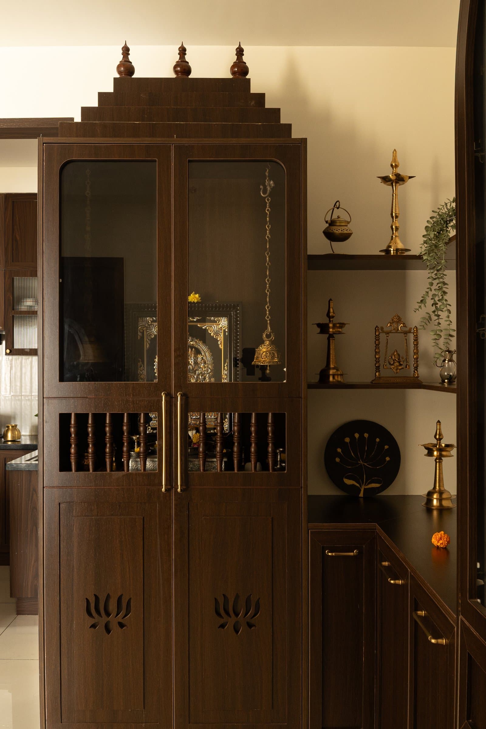The puja enclosure, a stepped wooden cabinet with lotus cutouts that recalls the spatial logic of traditional South Indian shrines
