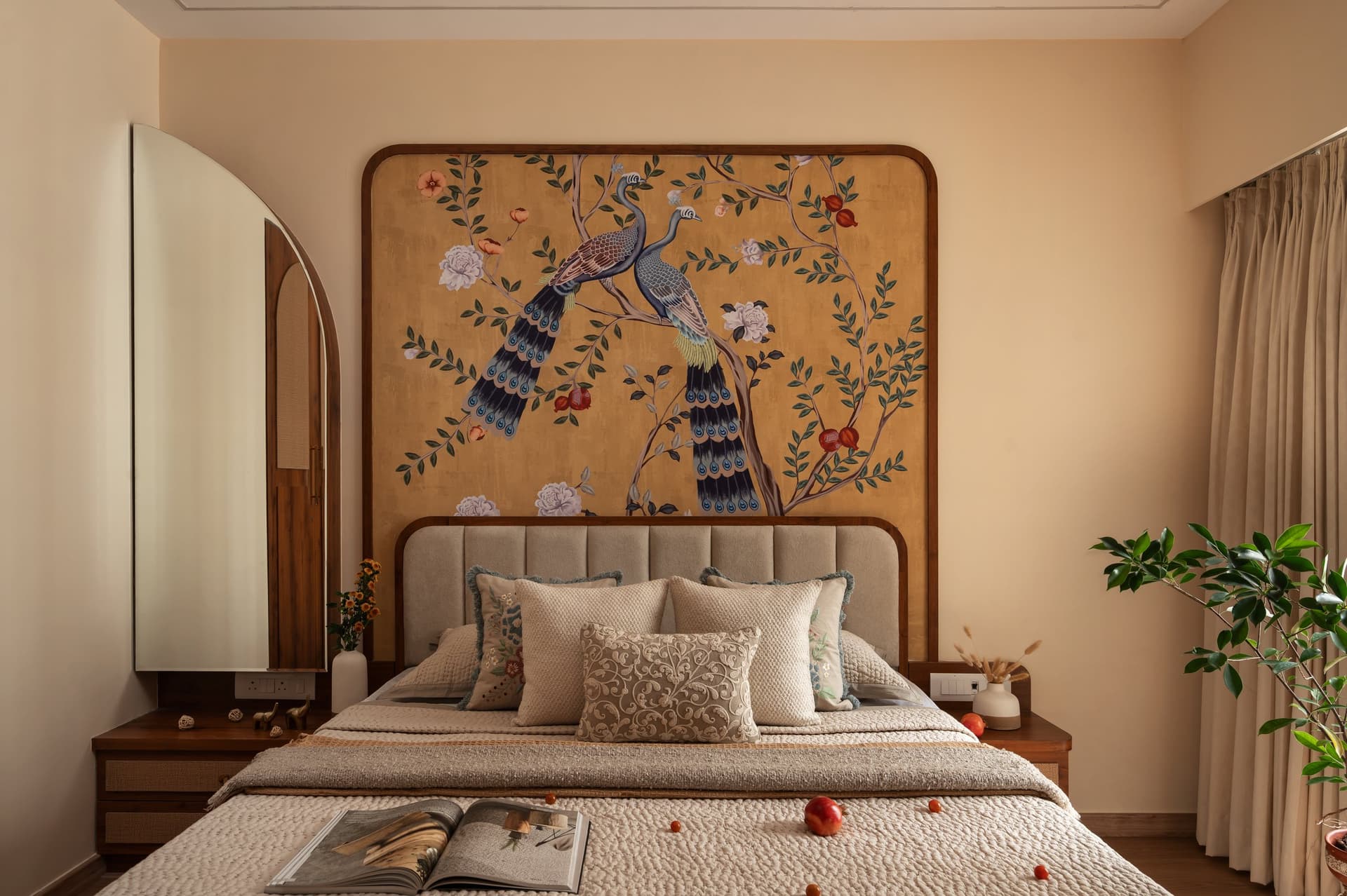 The primary bedroom, where a hand-painted peacock mural sits within a rounded wooden surround above the bed