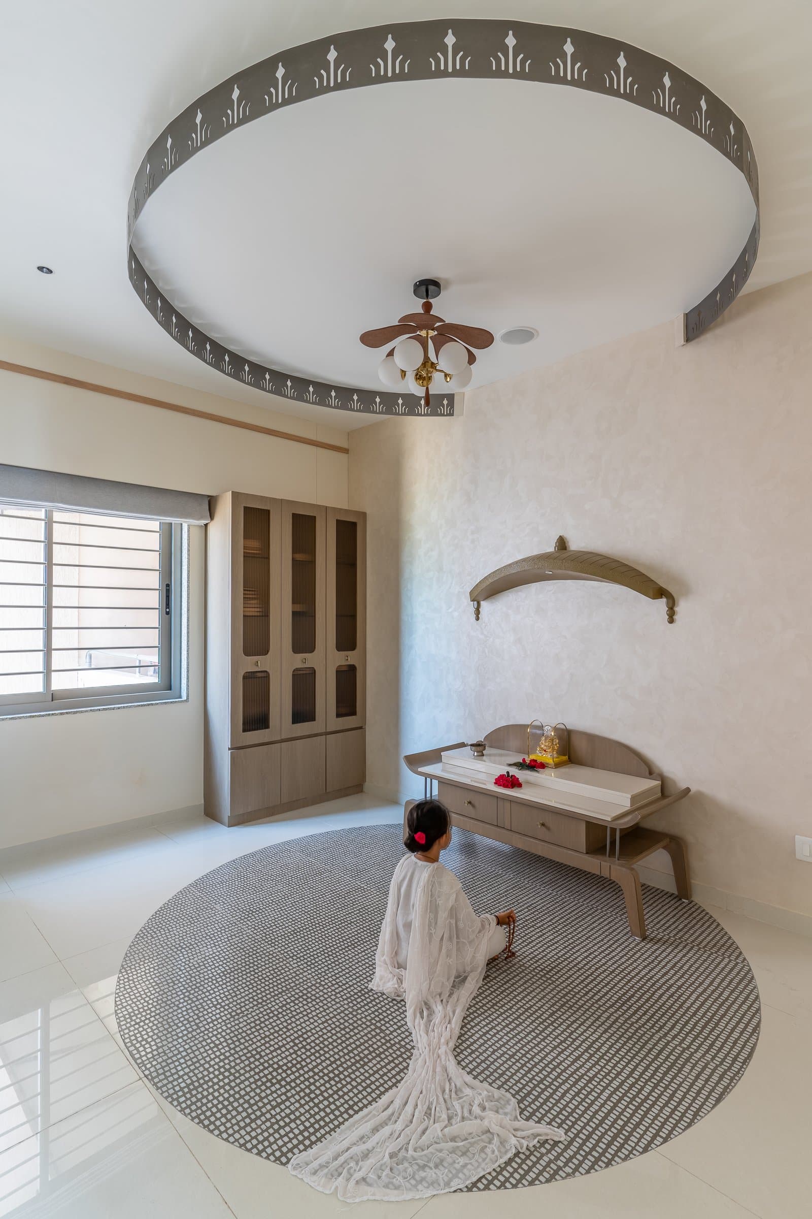 The puja room, where a circular dropped ceiling with laser-cut detailing integrates function and belief into the architecture