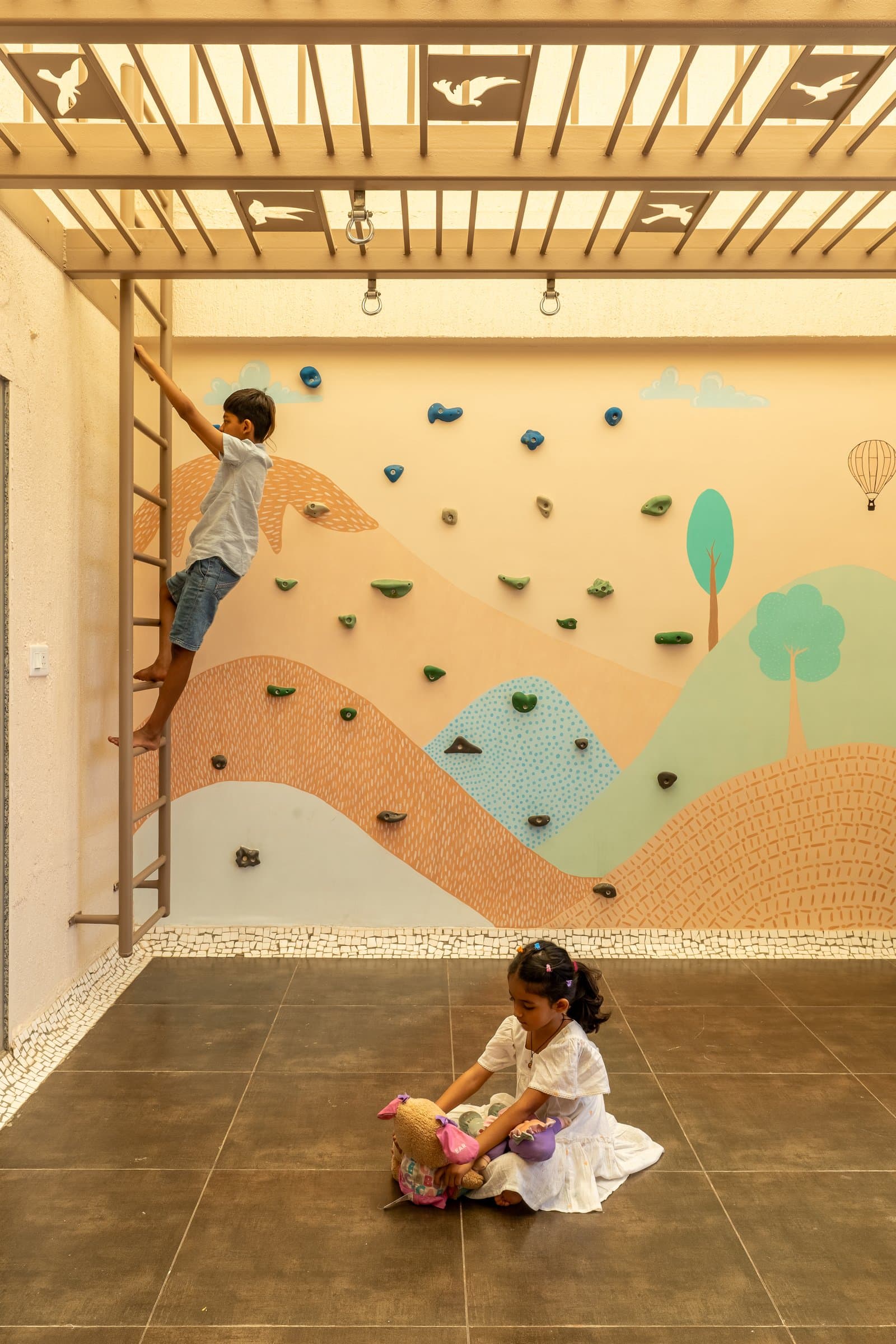 The terrace, where a climbing wall painted with hills and a hot-air balloon extends the home's palette outdoors