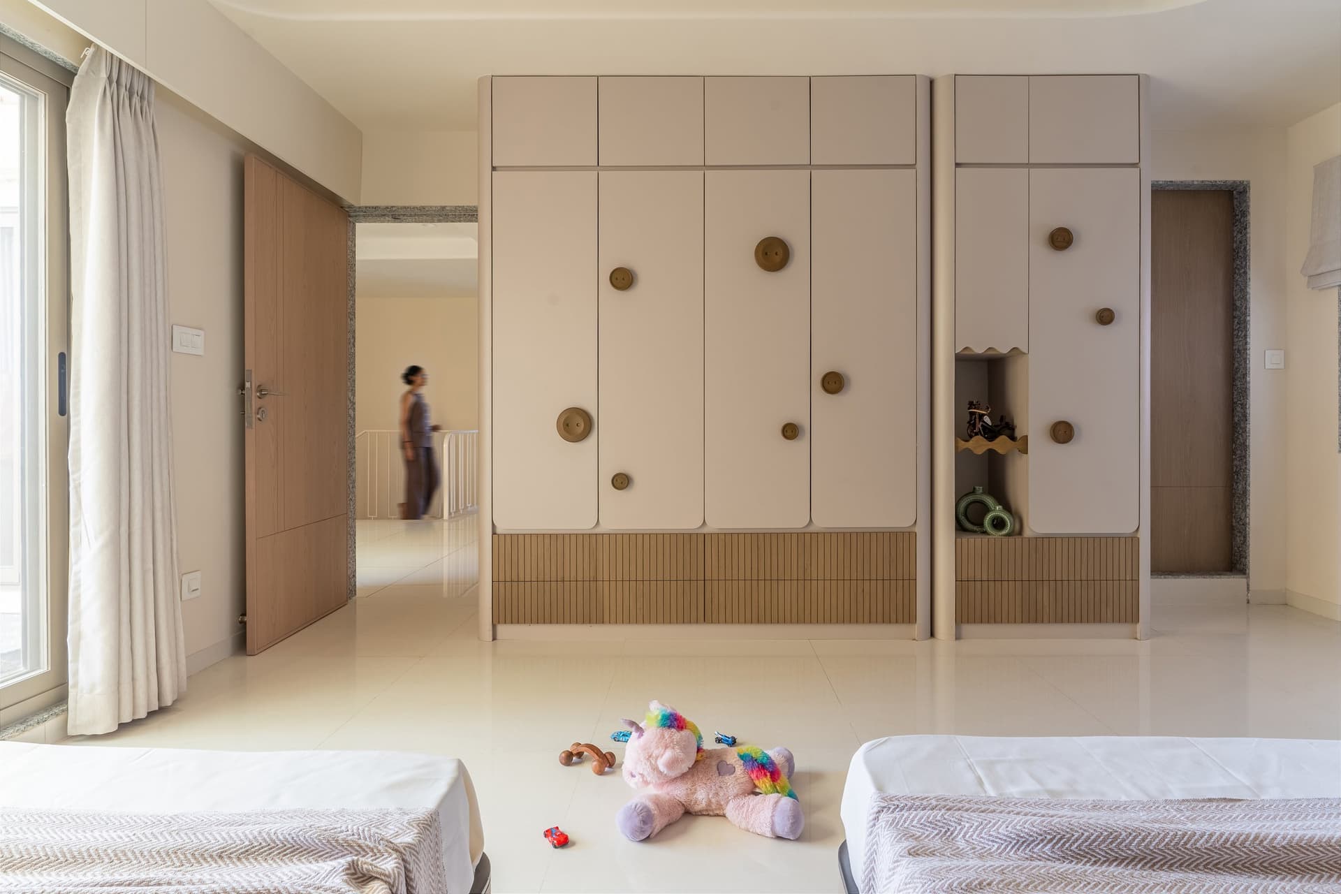The storage wall opposite the children's beds, with oversized decorative buttons applied to the wardrobe doors