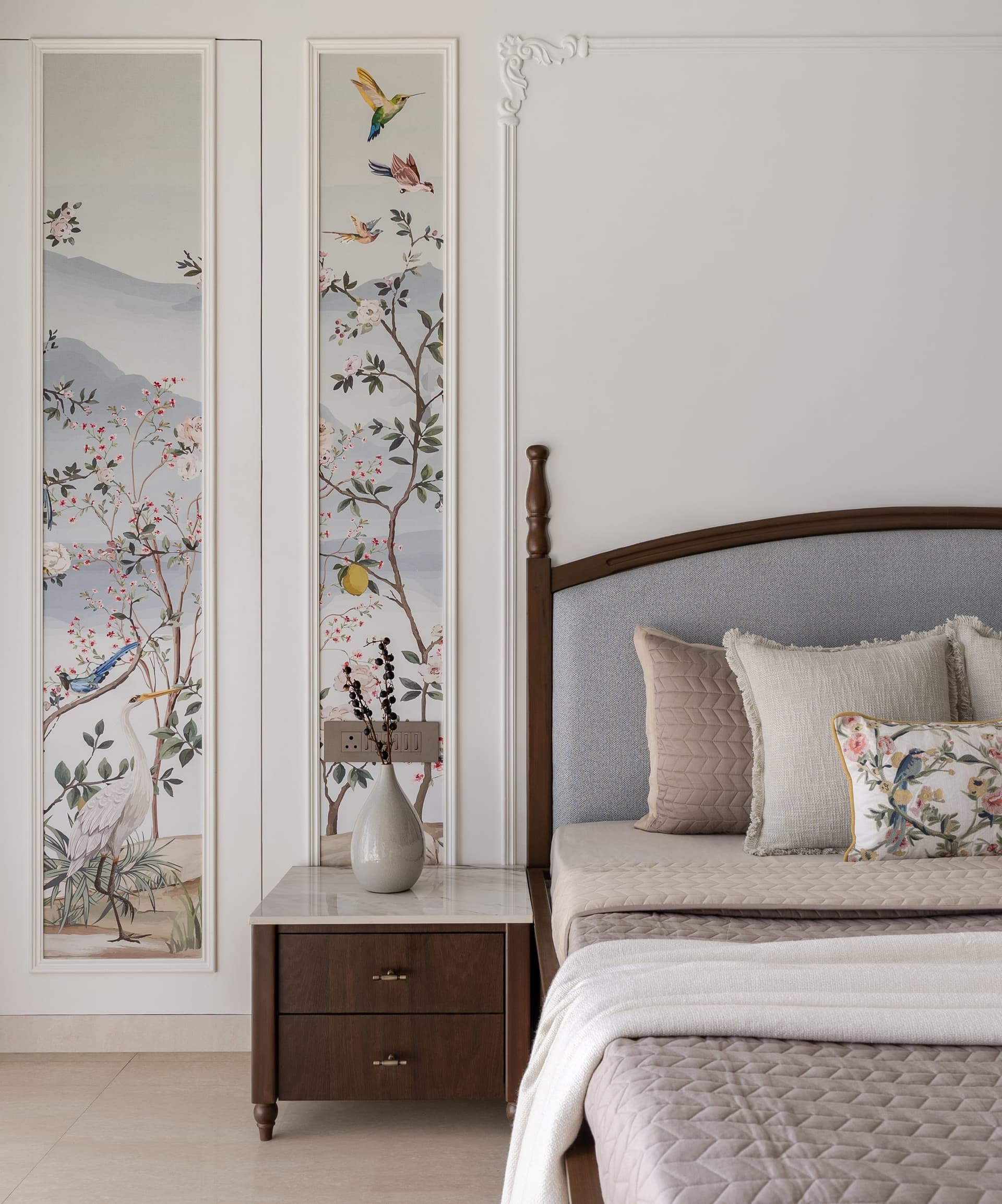The painterly botanical panels framed as artwork beside the master bed