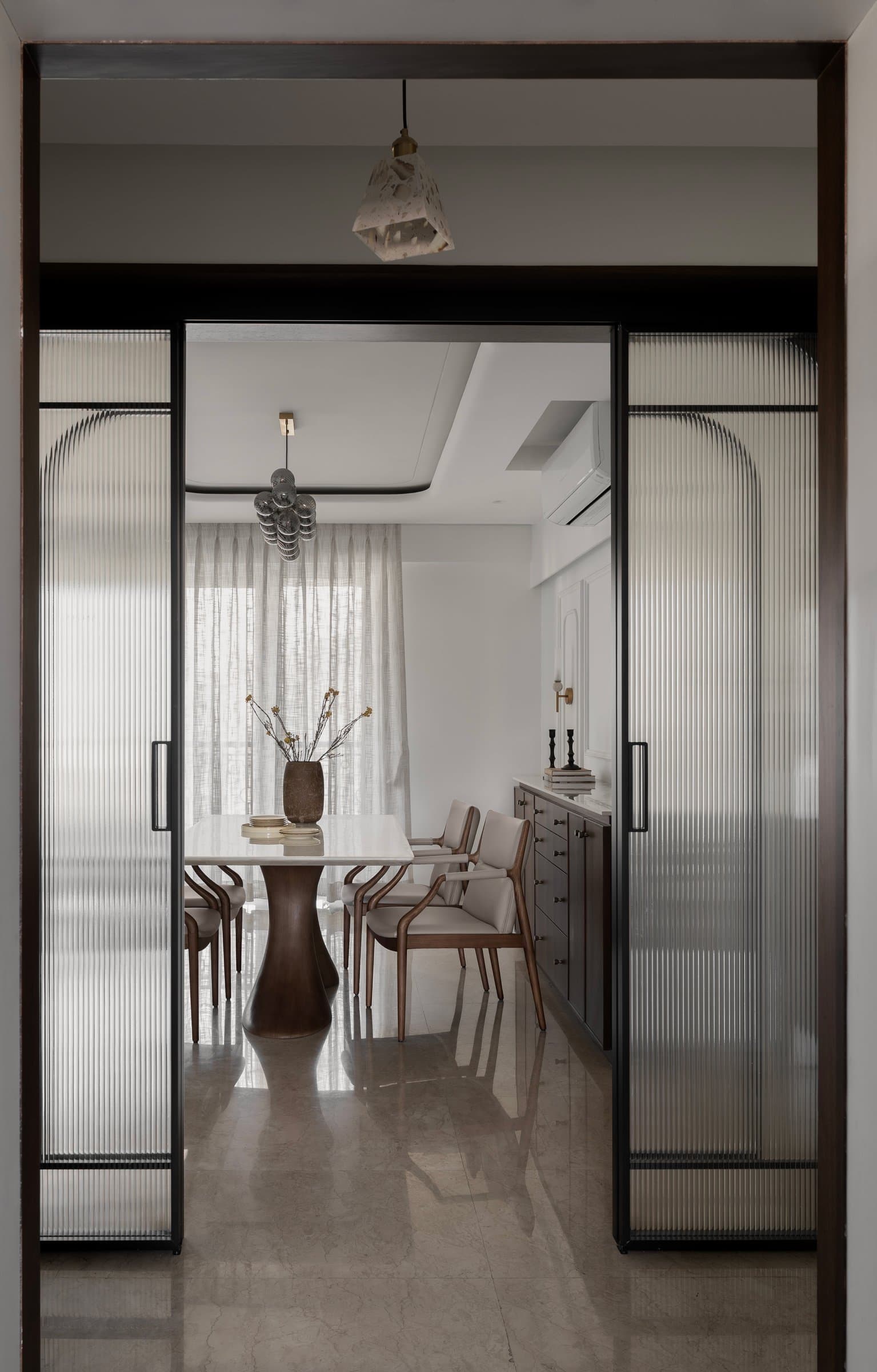 The view from the entry into the dining area, framed by fluted-glass sliding doors